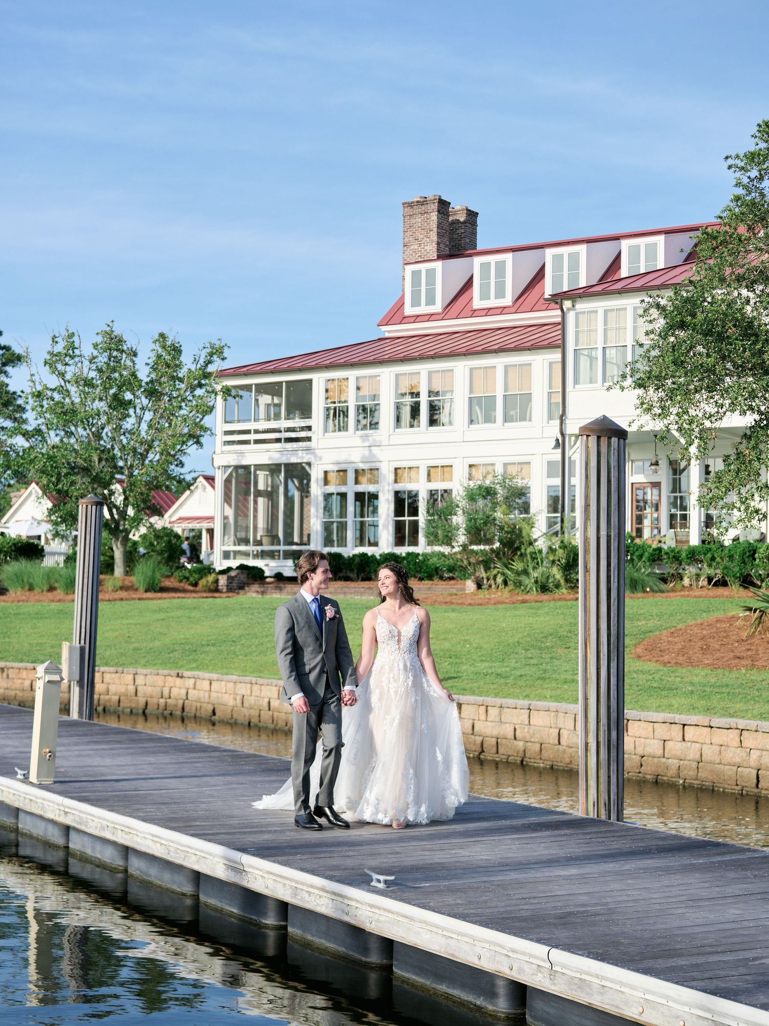 Elegant waterfront venue with historic mansion and wooden dock overlooking the water.