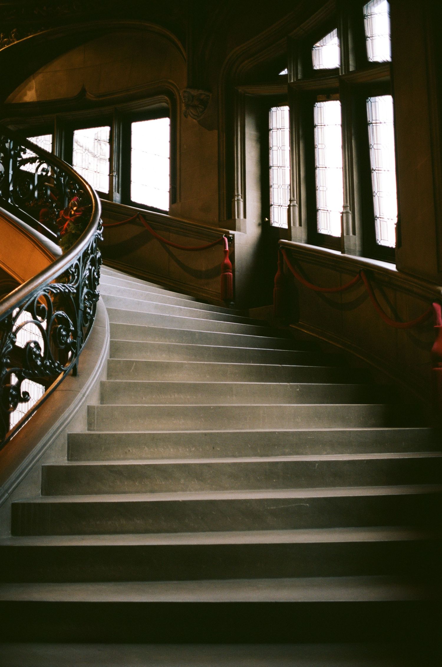 Grand curved staircase with decorative iron railings in historic building.