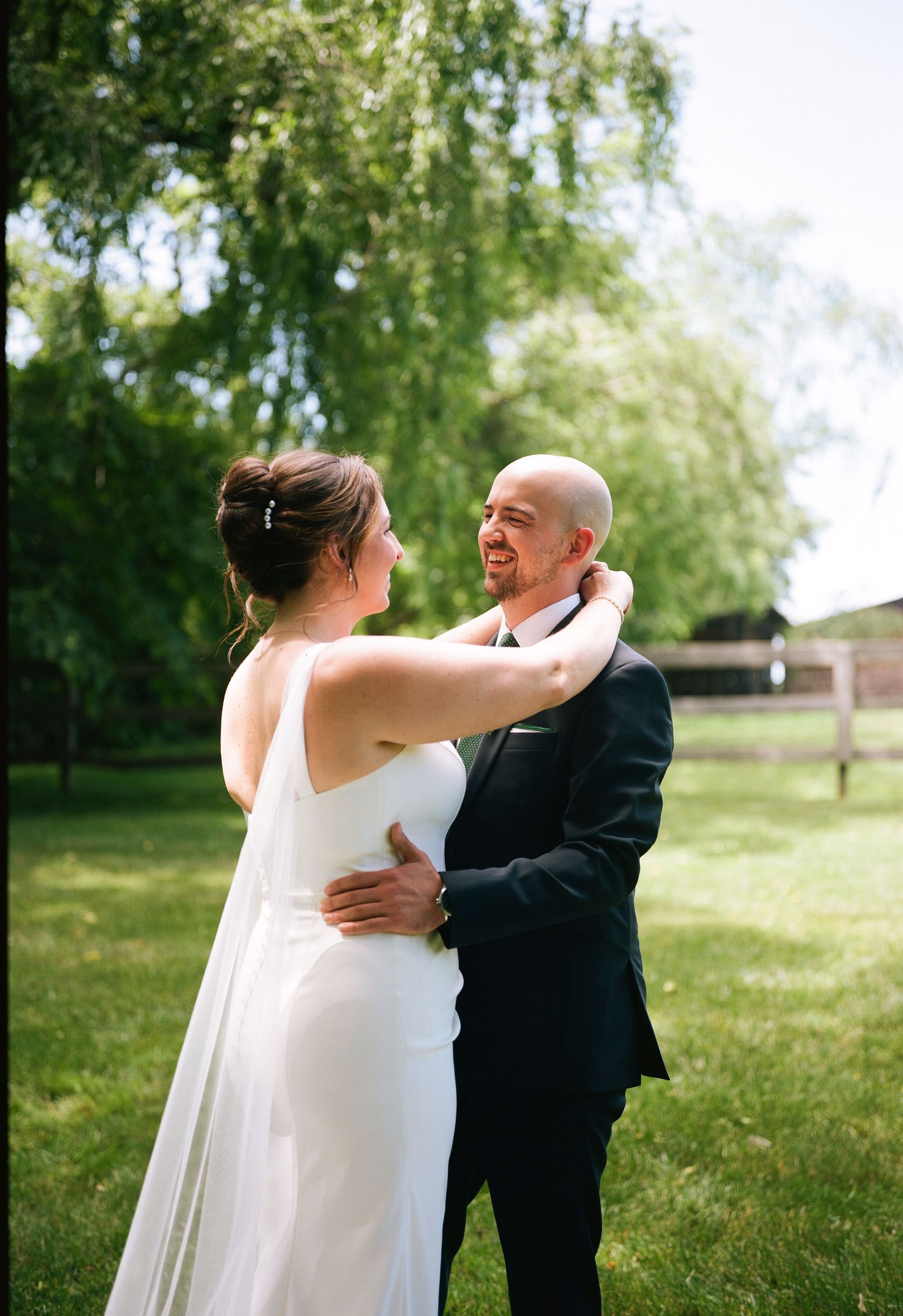 A tender moment between newlyweds in a lush green garden setting.