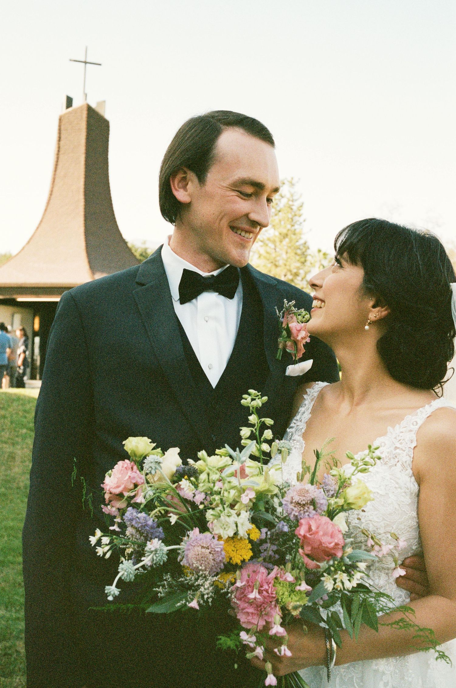 Happy couple sharing a joyful moment during outdoor wedding ceremony.