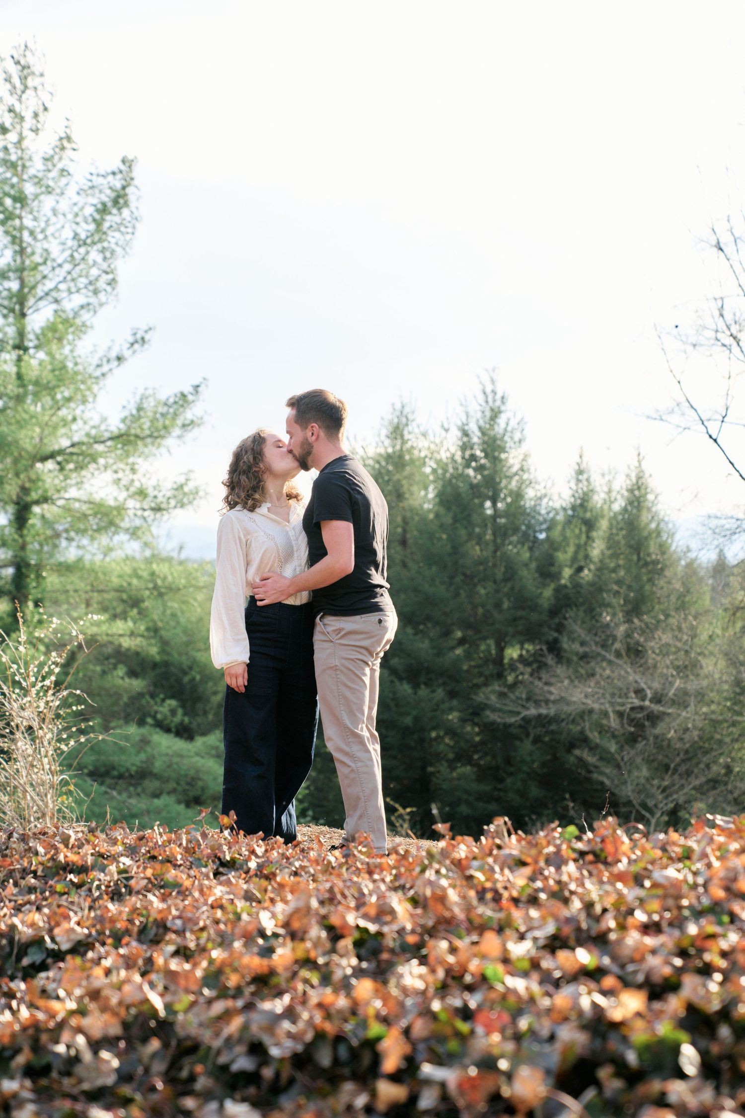 Couple kissing next to the Biltmore gardens during their engagement photos