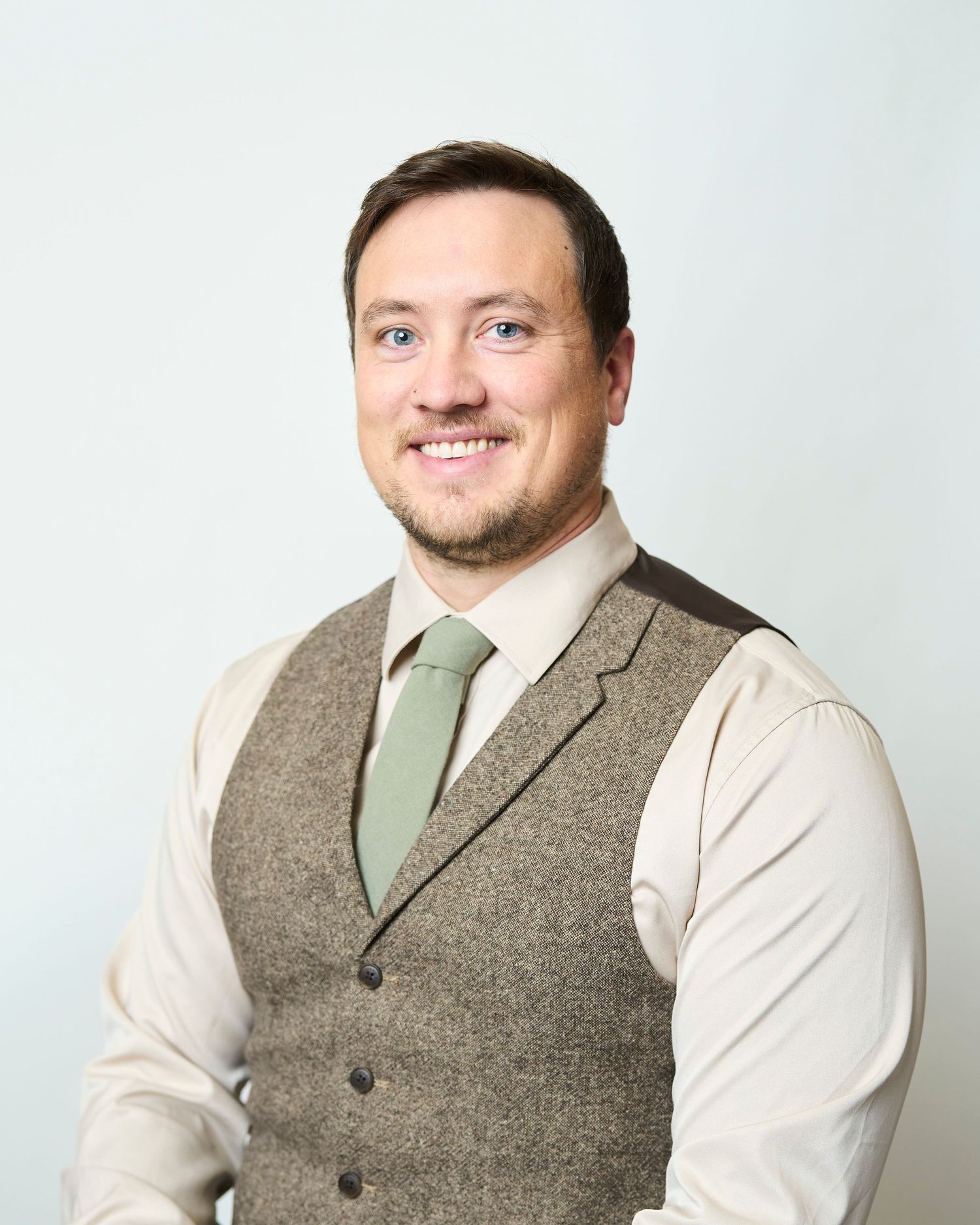 Professional headshot in asheville of a men sitting in front of a white background.