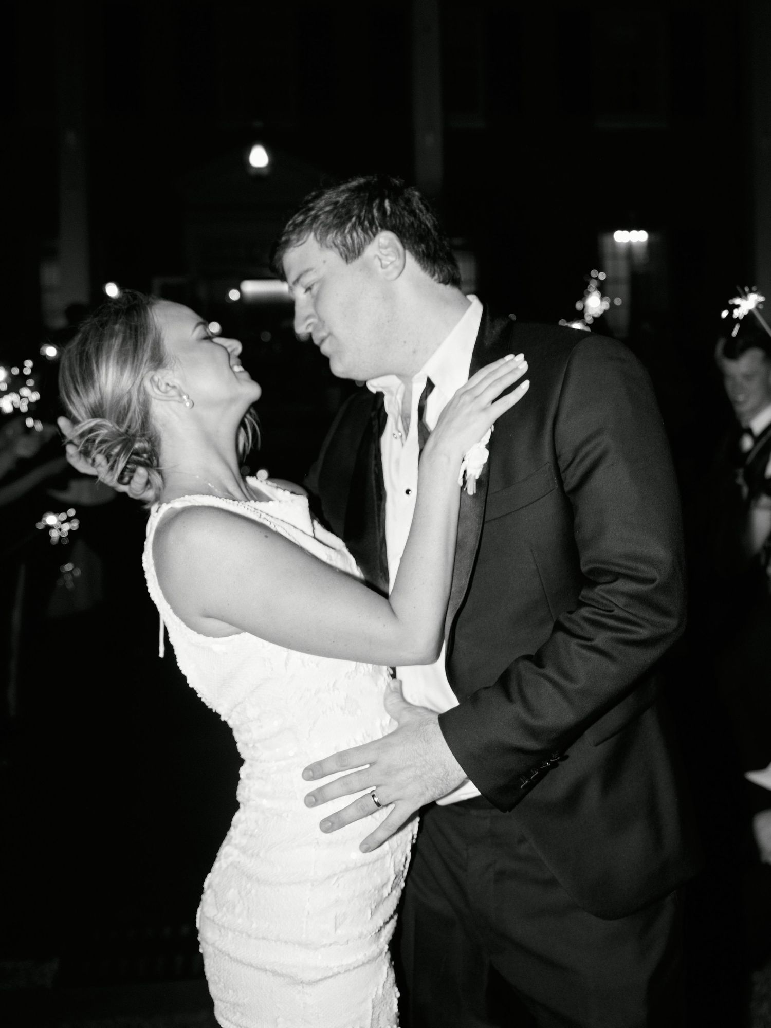 A black and white photo captures an intimate moment between newlyweds during their first dance.