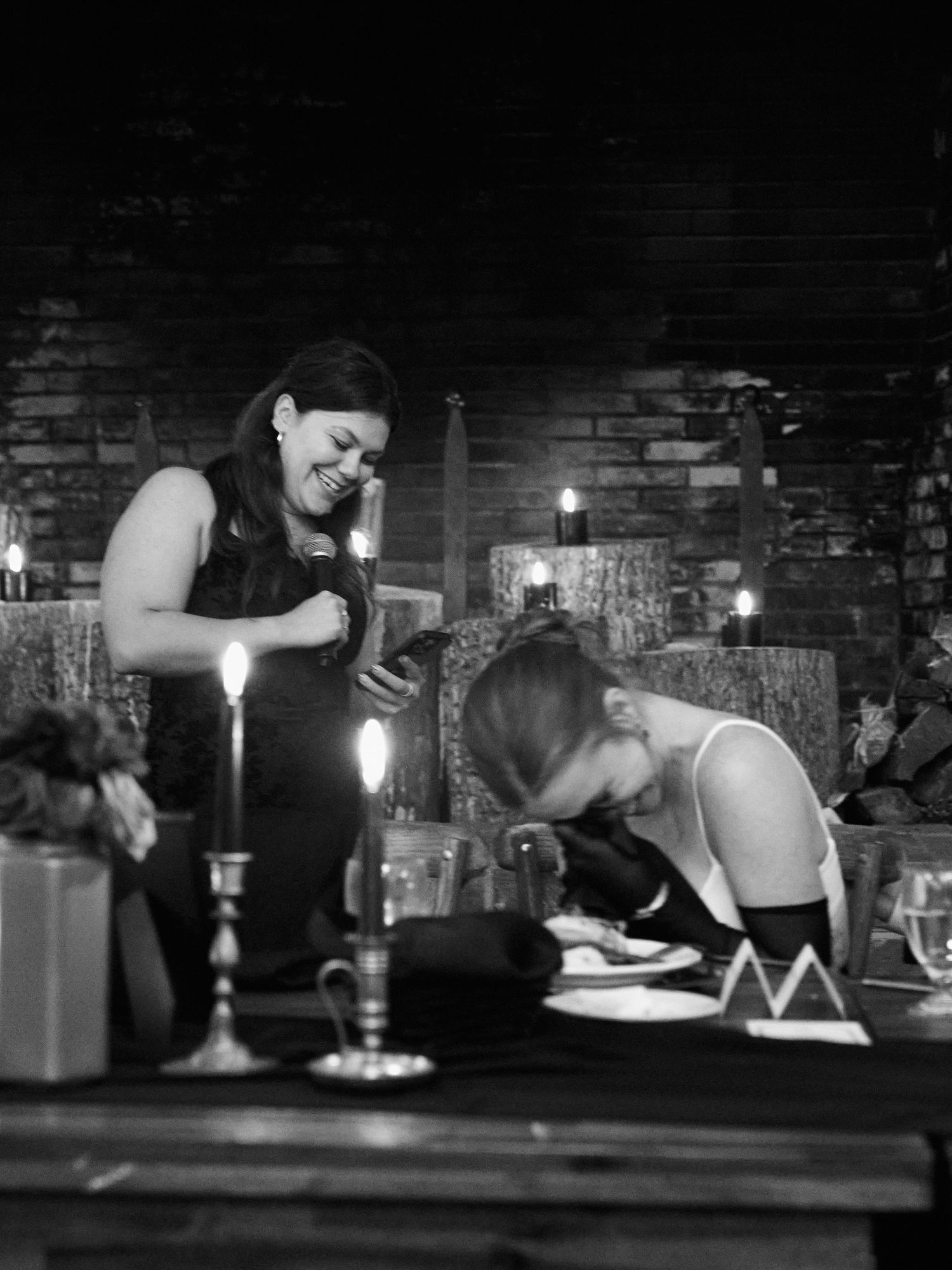 A candlelit reception dinner in a rustic venue with brick walls and vintage decor.