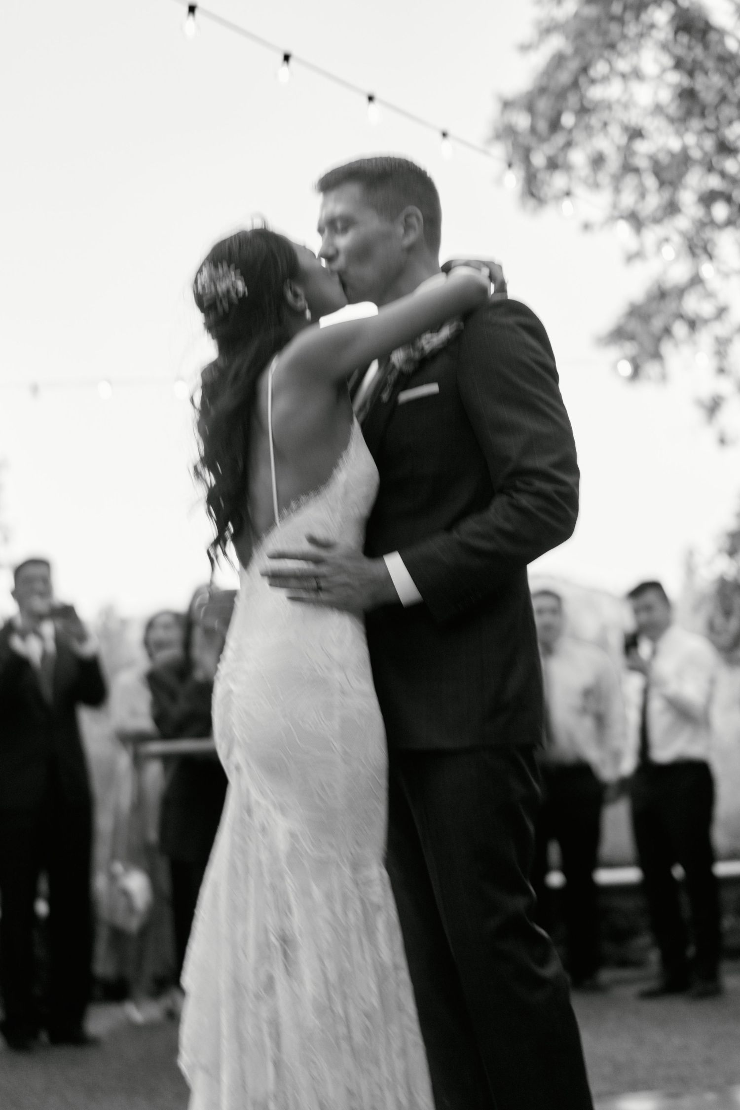 Black and white photo of newlyweds sharing an intimate dance moment at their outdoor reception.