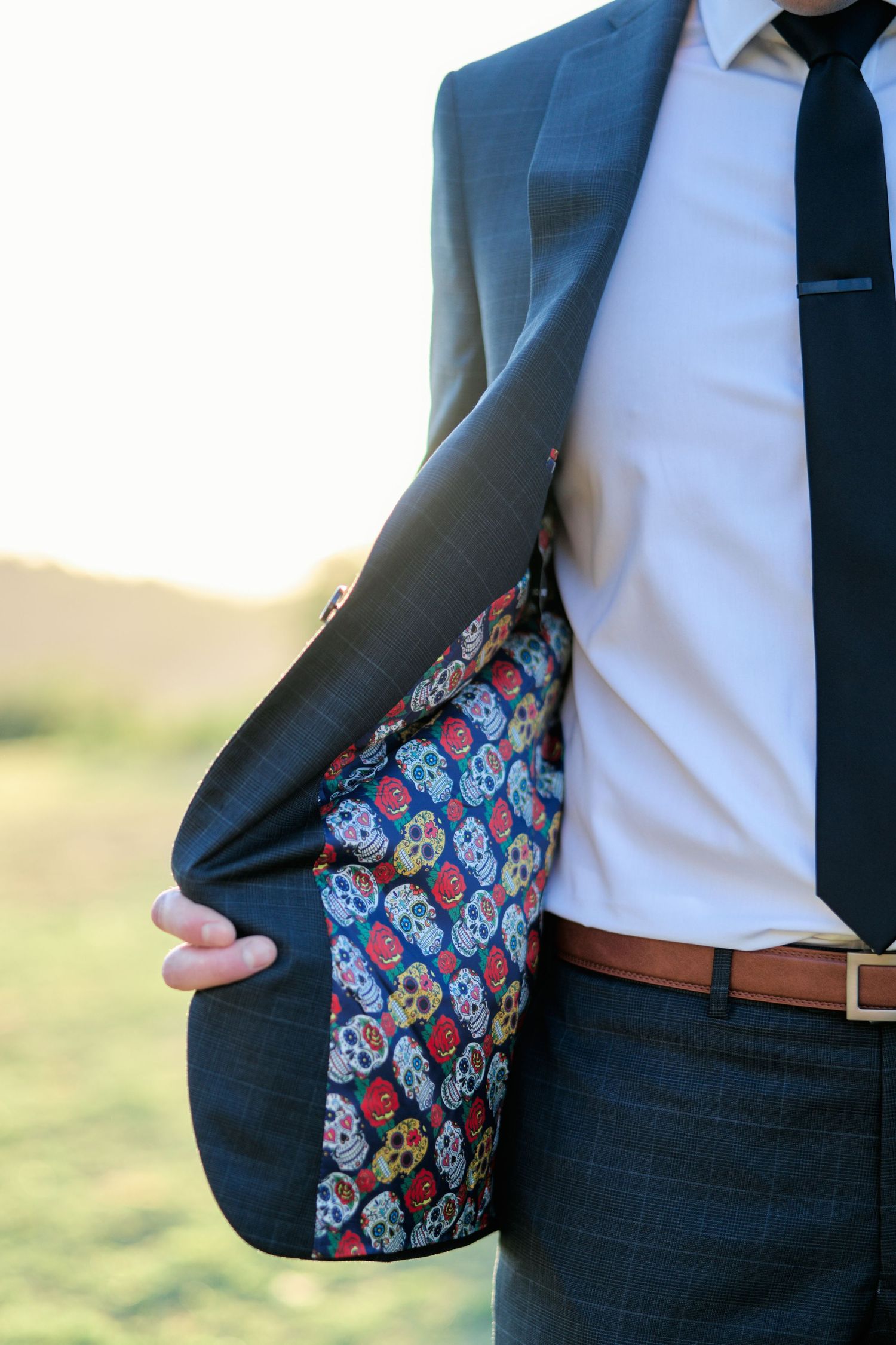 Detail shot of a suit jacket revealing colorful skull-patterned lining.