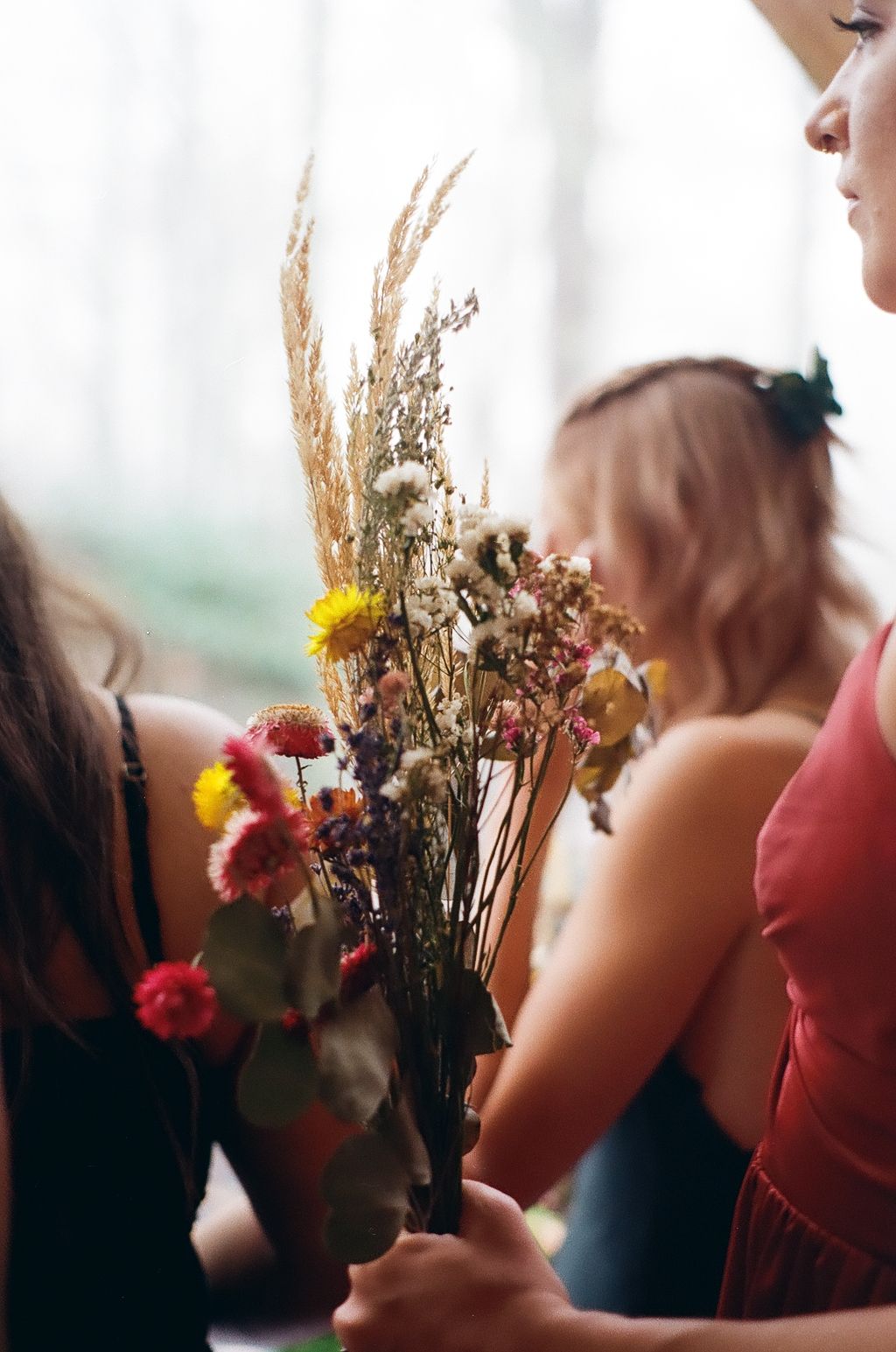 Dried flowers and colorful blooms being arranged at a wedding celebration.