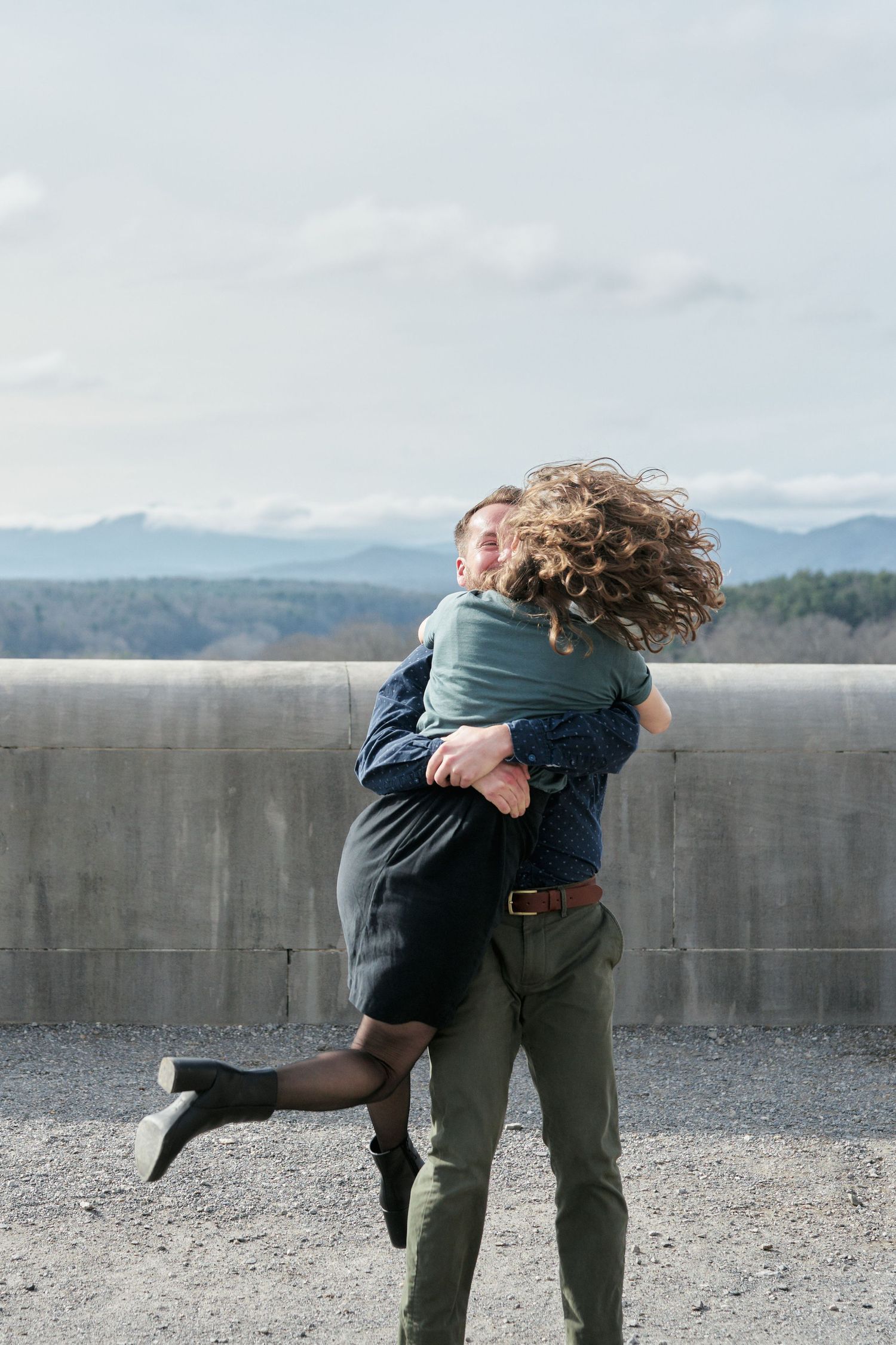 Couple hugging and spinning during their engagement photos at the Biltmore Estate.