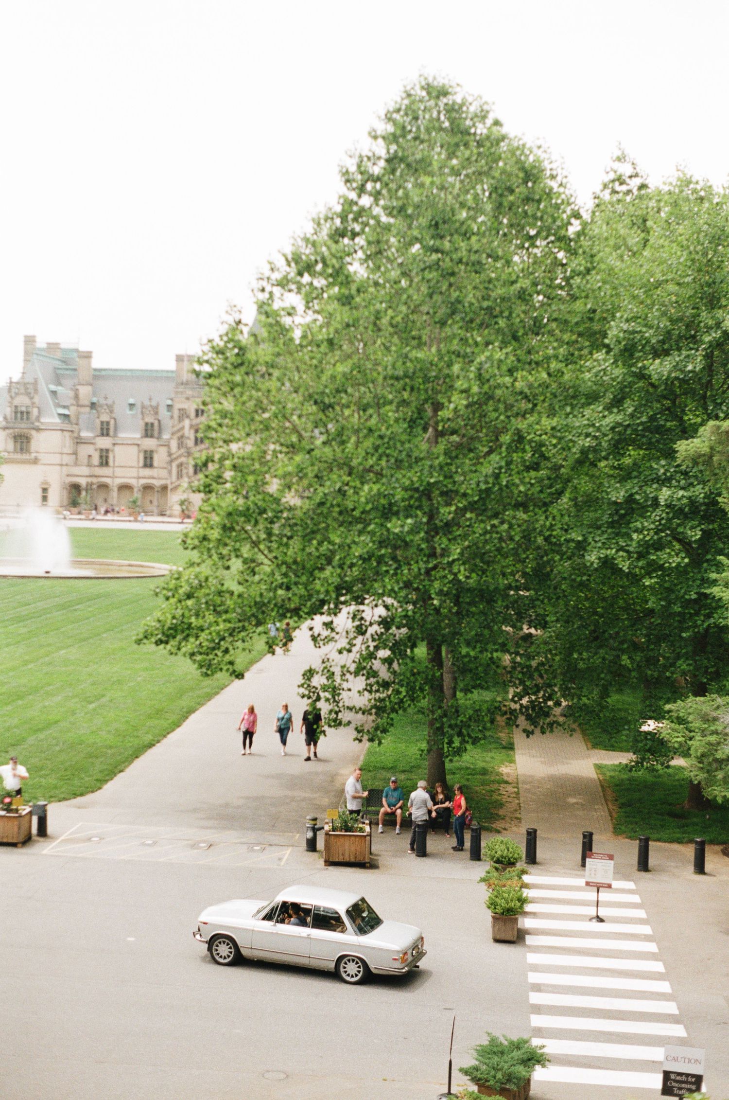 Photo of a Bmw 2002 driving in front of the Biltmore estate shot on film photography.