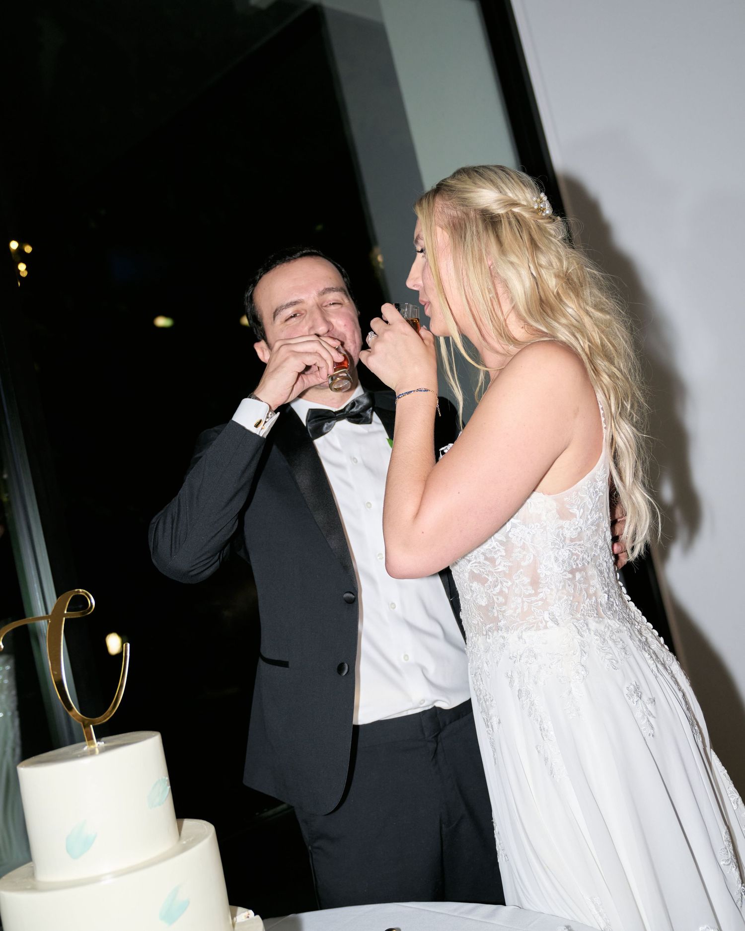 Wedding couple sharing a playful moment while feeding each other wedding cake.