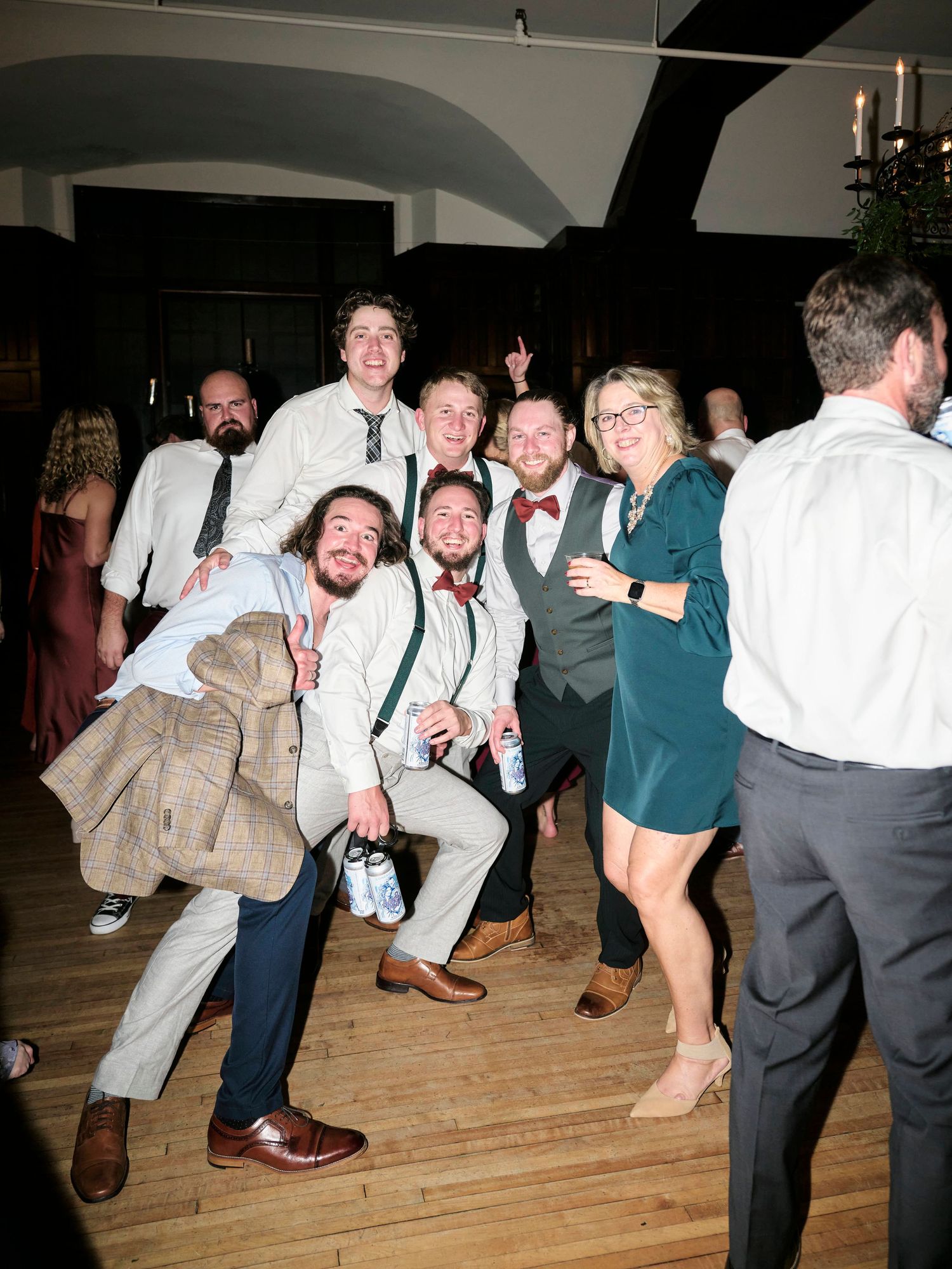 Group of wedding guests posing playfully for a photo on the dance floor.