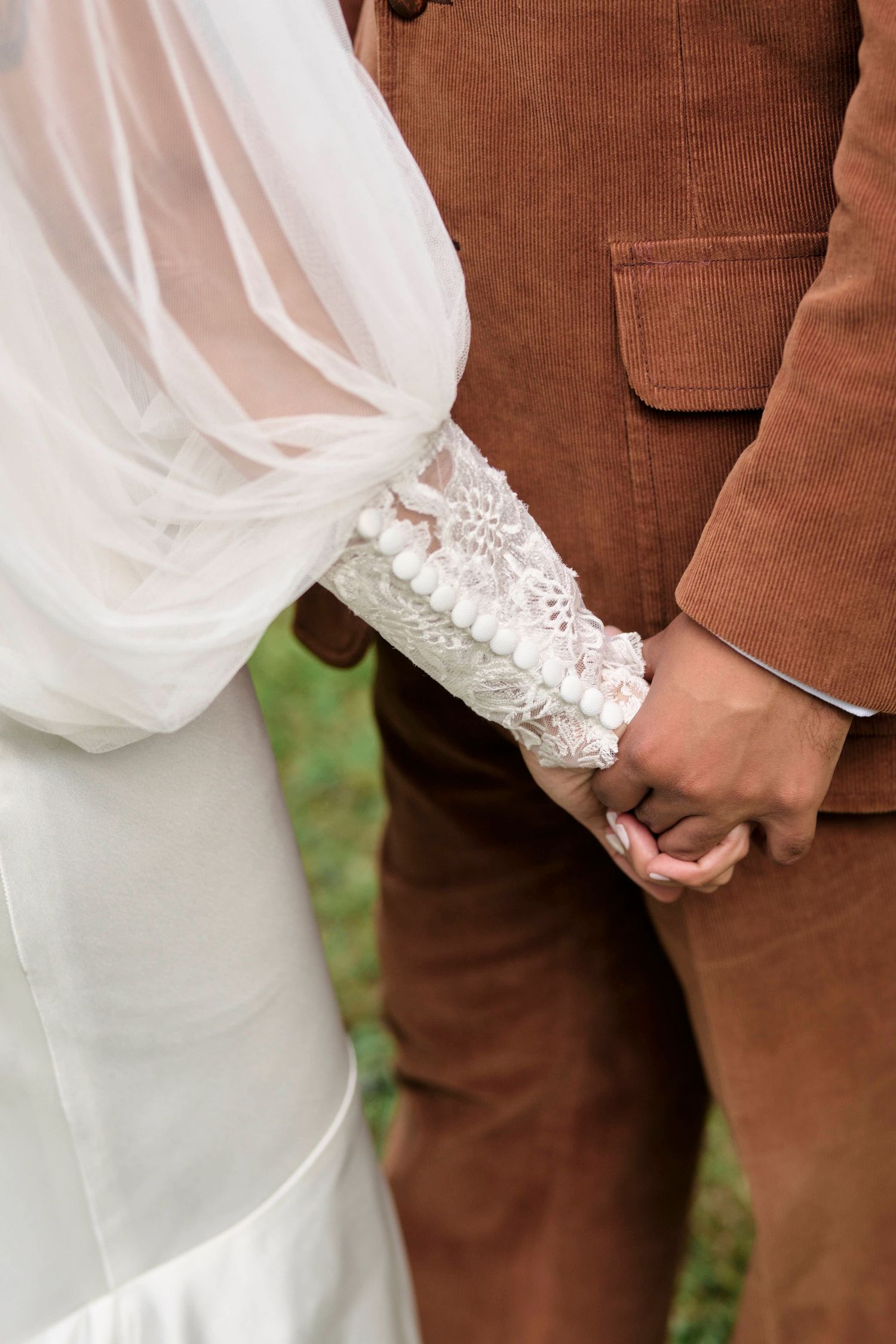 Detail photo of bride and groom holding hands during their wedding photos in Tennessee