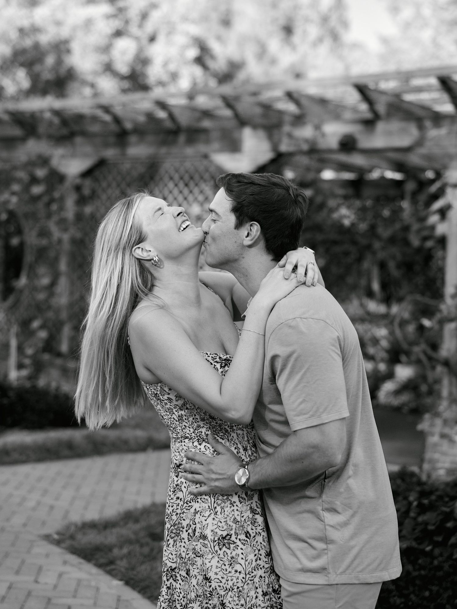 A romantic couple shares tender kisses in a series of black and white outdoor photos.