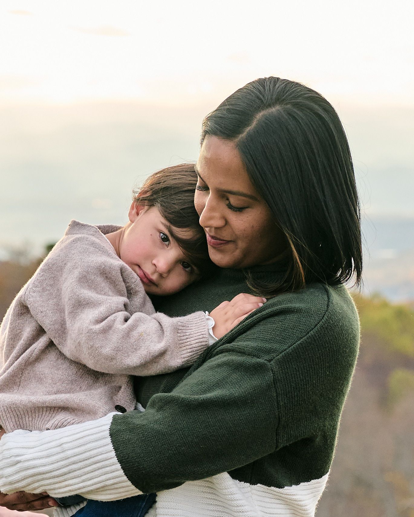 A parent and child share tender embraces in a series of heartwarming outdoor photos at sunset.