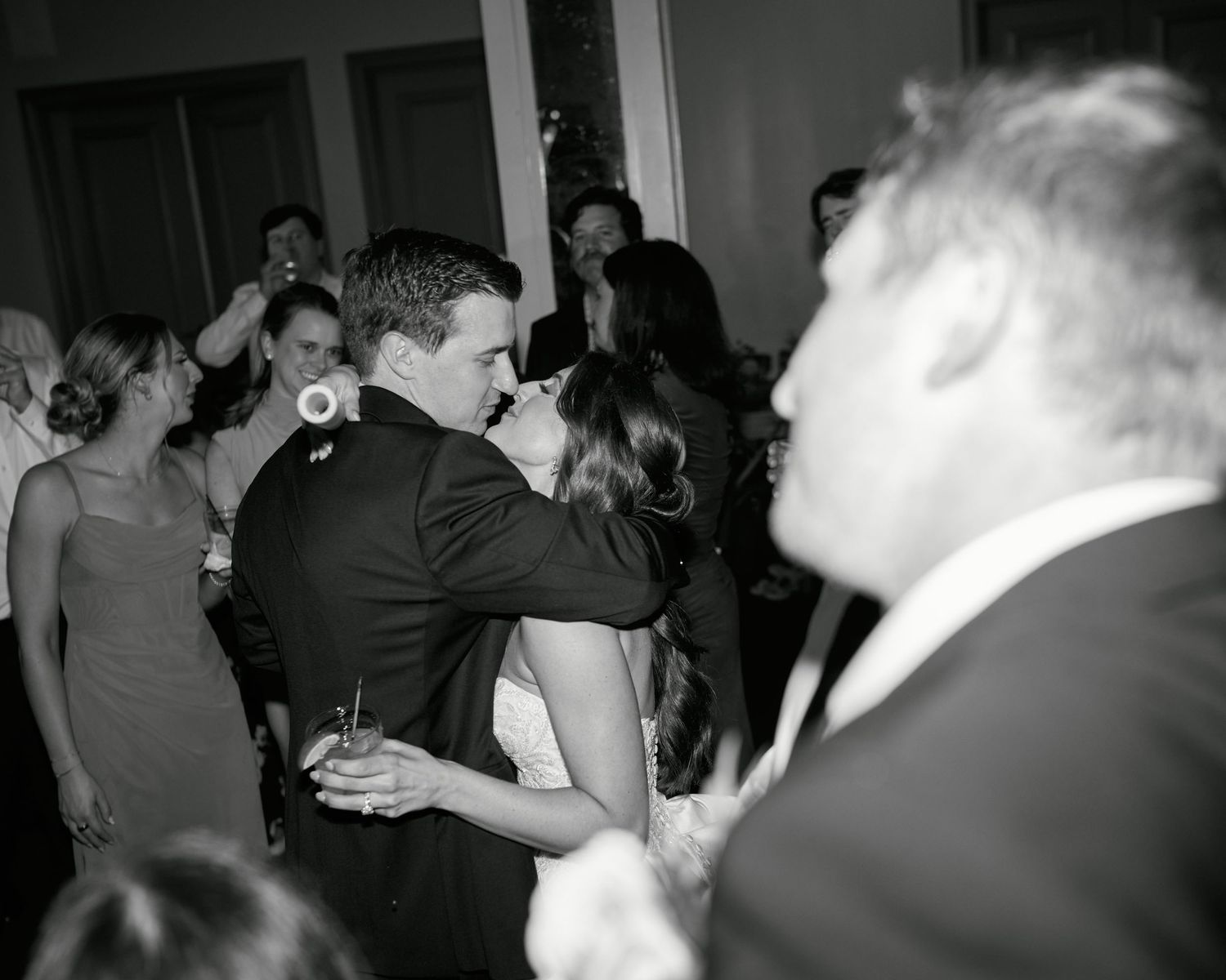 People dancing together at a black and white party or social gathering on a dance floor.
