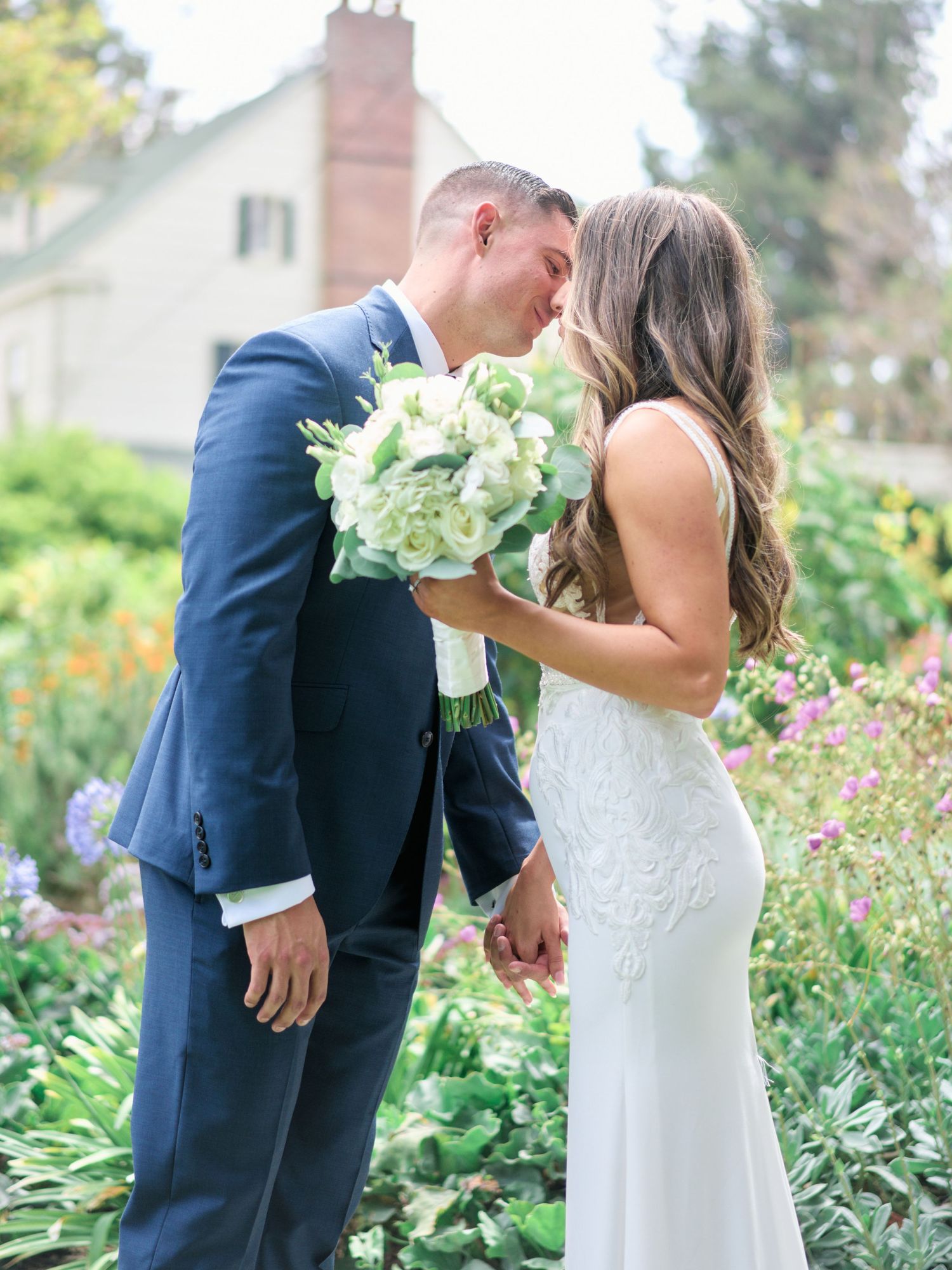 Romantic moment shared between couple with white hydrangea bouquet in garden setting.