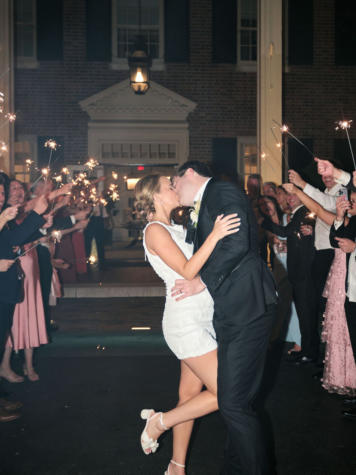 Newlyweds share a romantic moment under sparklers during their wedding send-off.