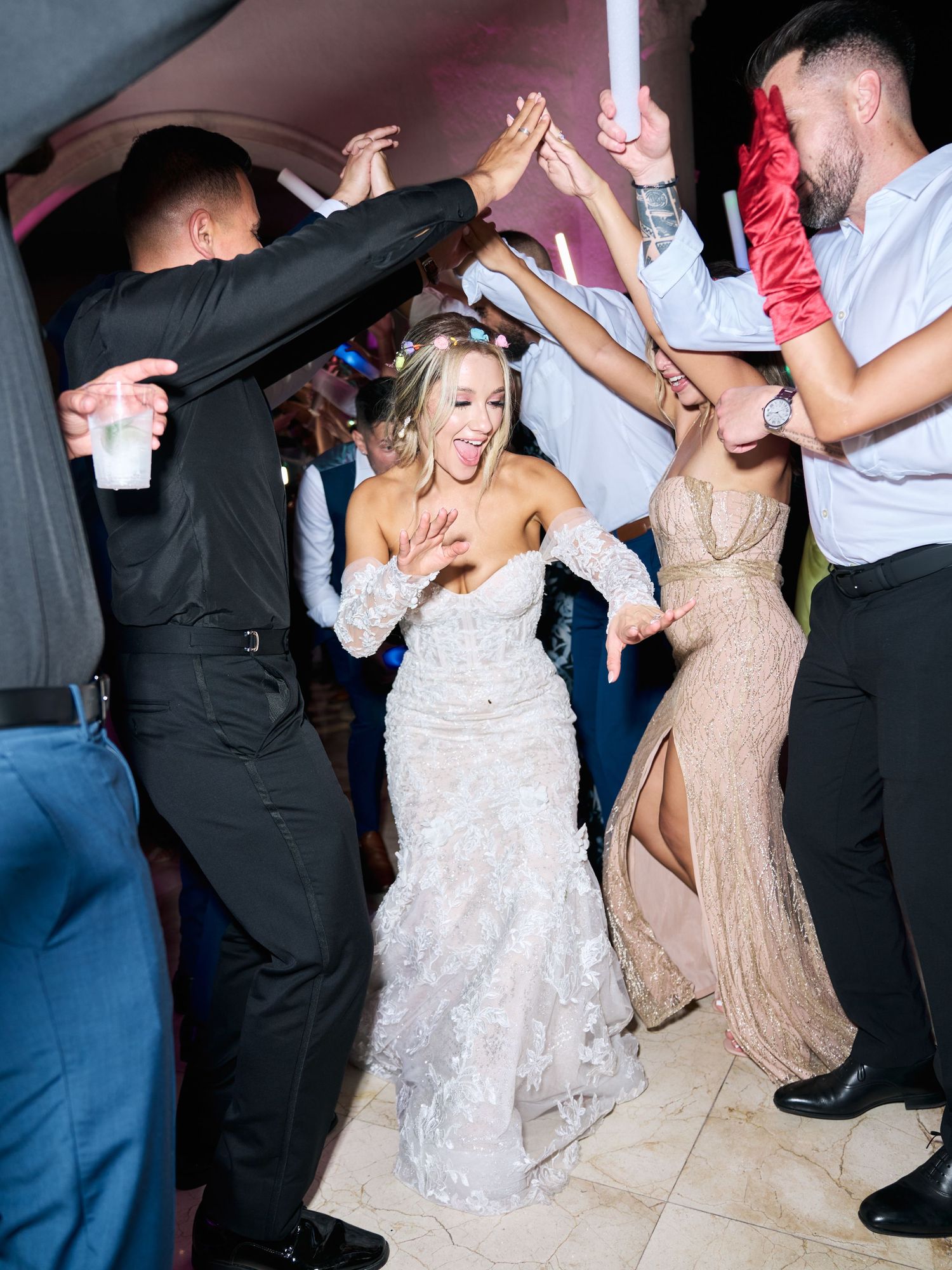 Wedding reception party guests dancing and celebrating on the dance floor.