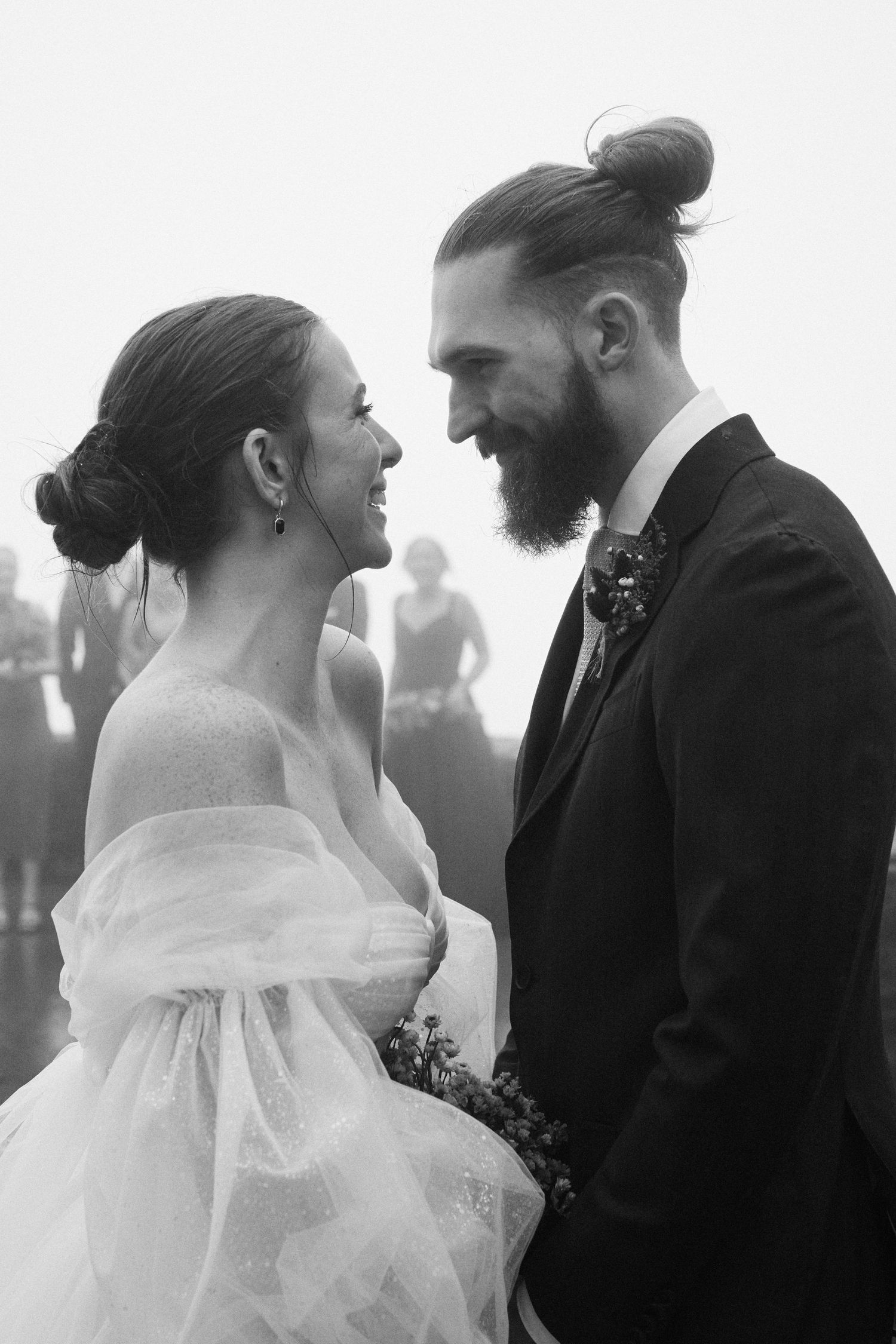 A black and white portrait of a joyful couple sharing a laugh during their wedding.