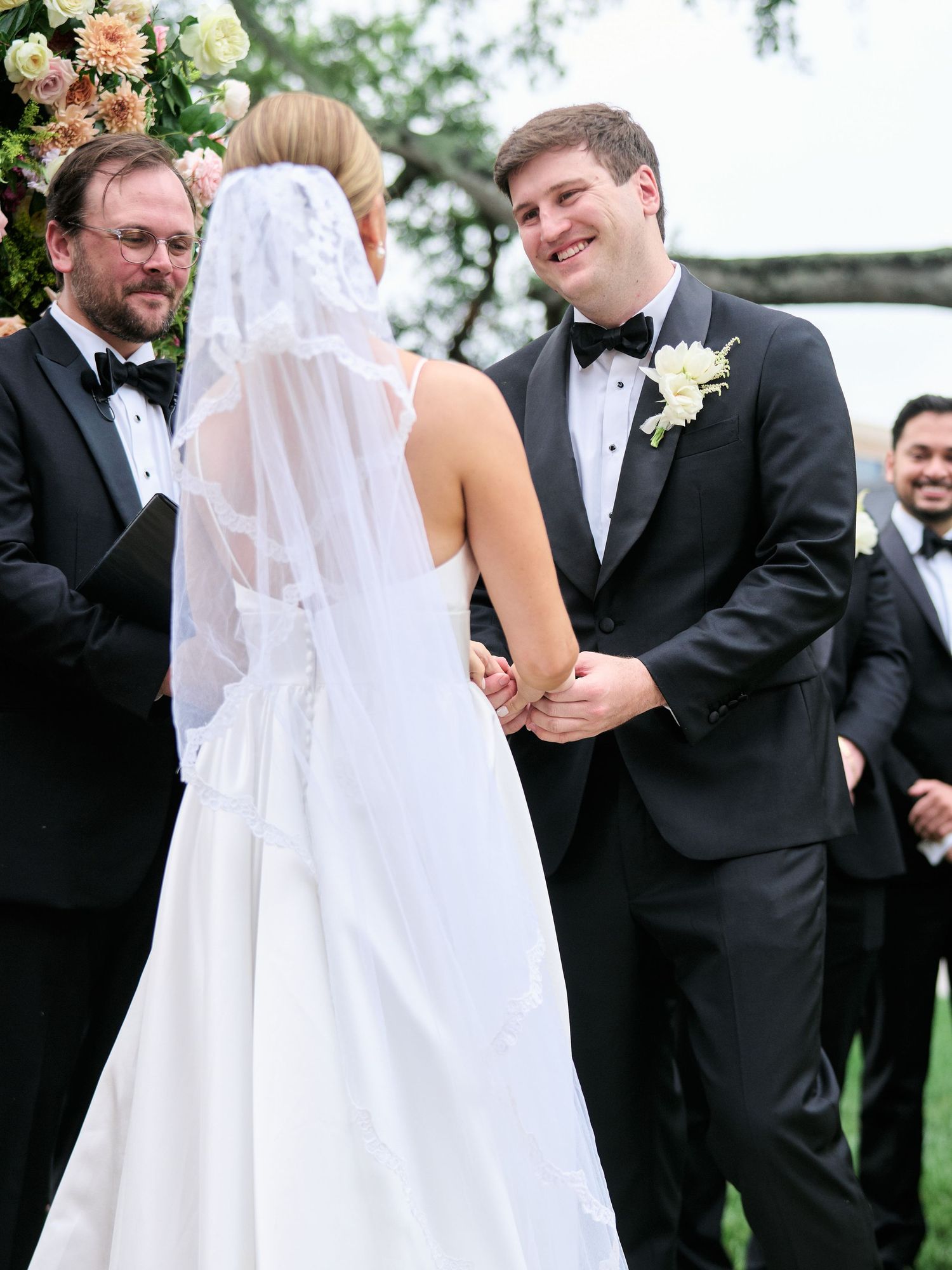 Wedding ceremony moment under floral arch with elegant decorations.