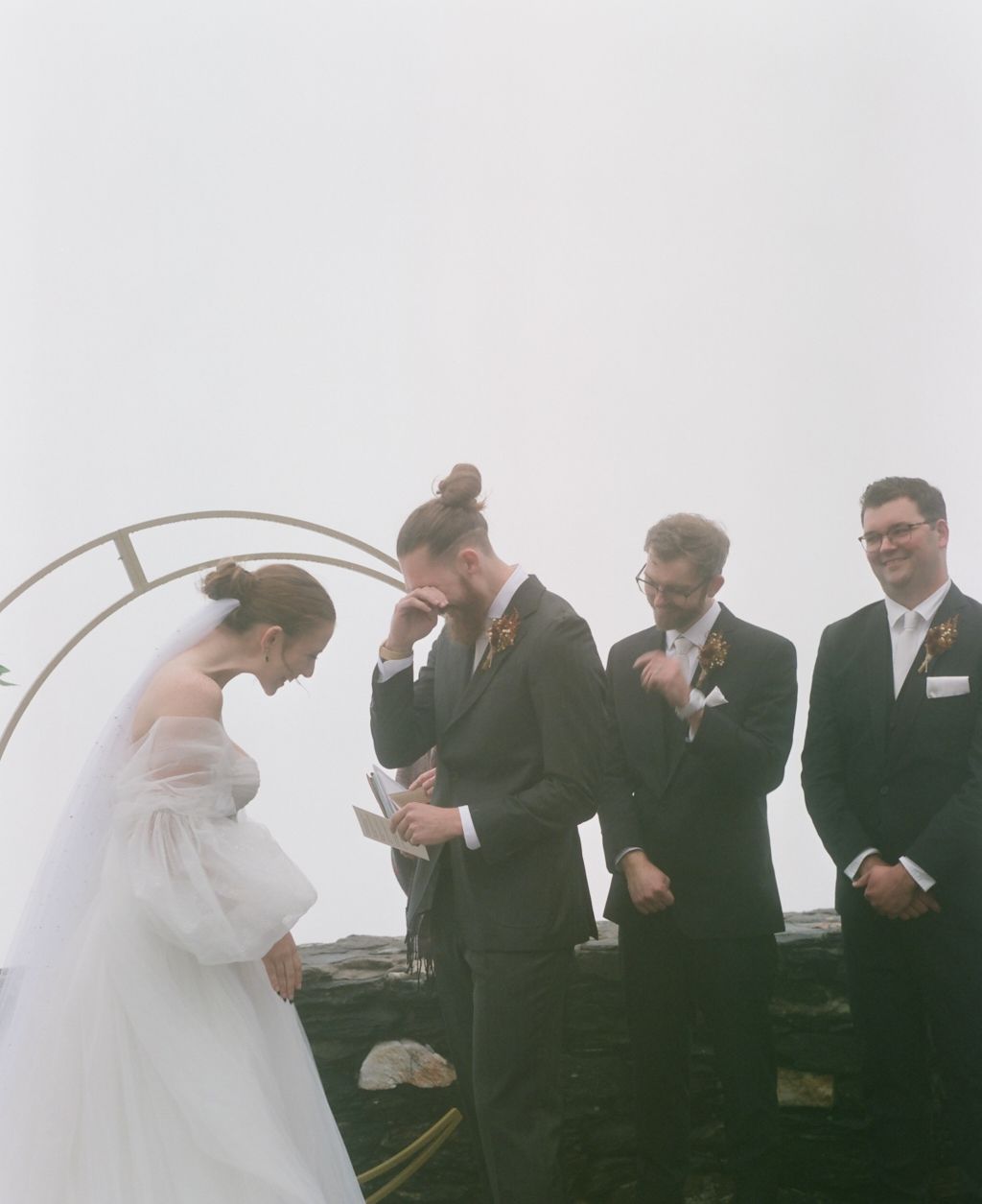 A wedding ceremony moment under an arch with emotional reactions during the vows.