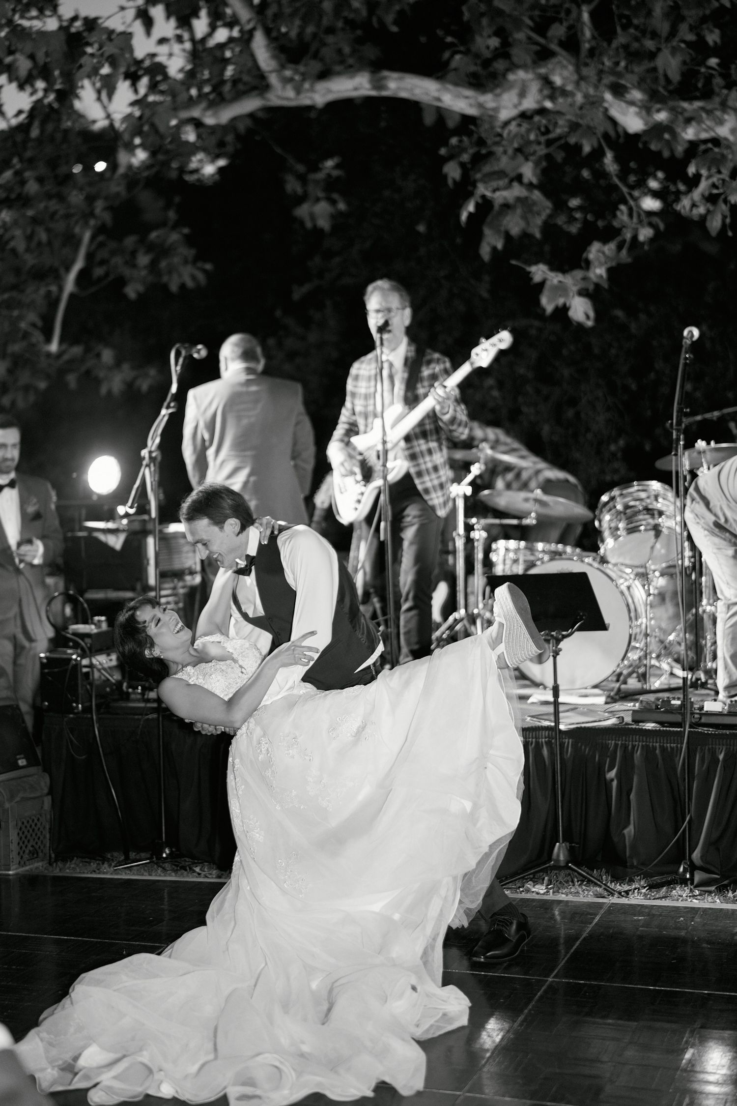 Live band performs on stage during evening outdoor reception.