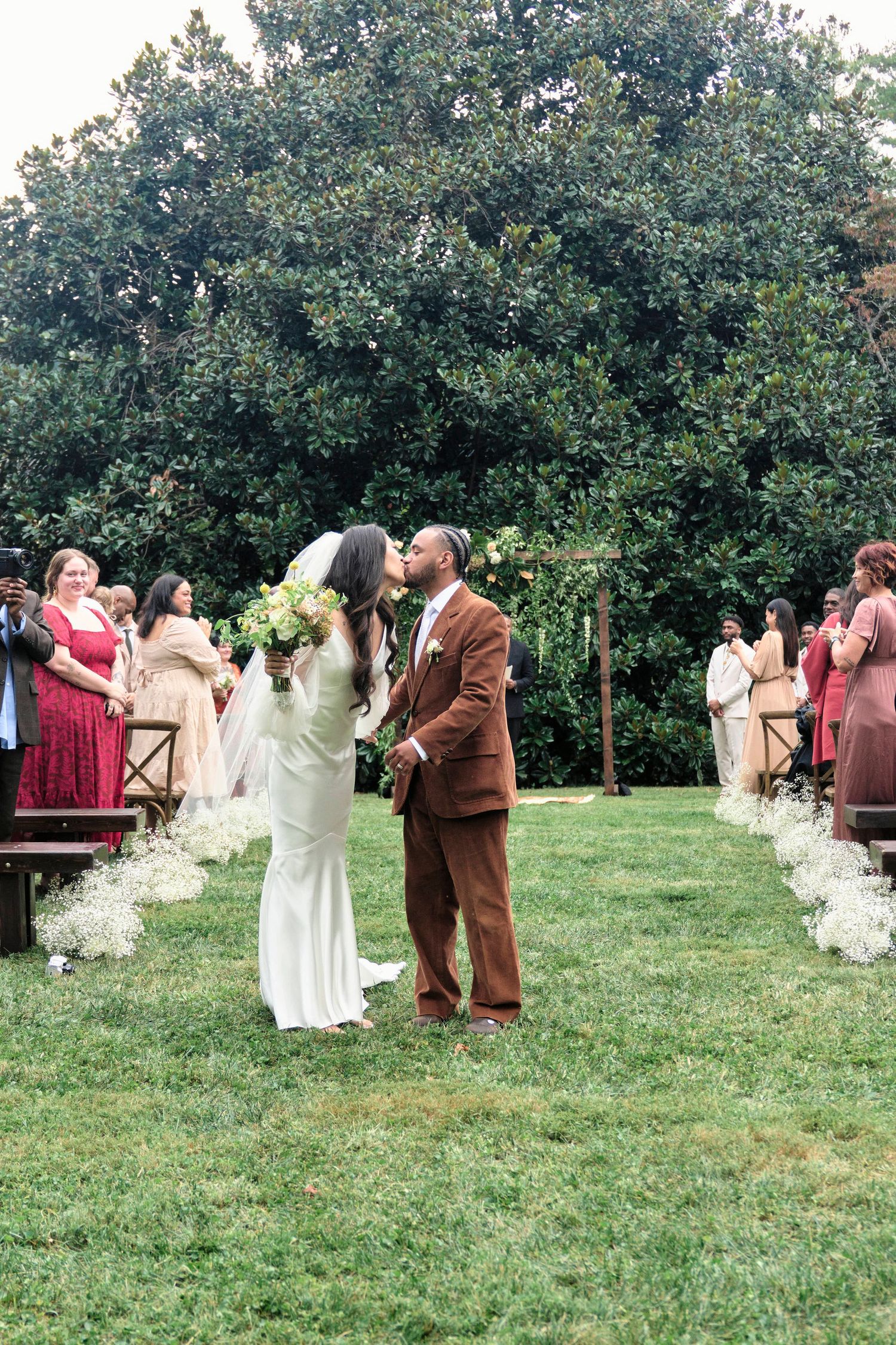 Bride and groom kiss during their wedding ceremony exit.