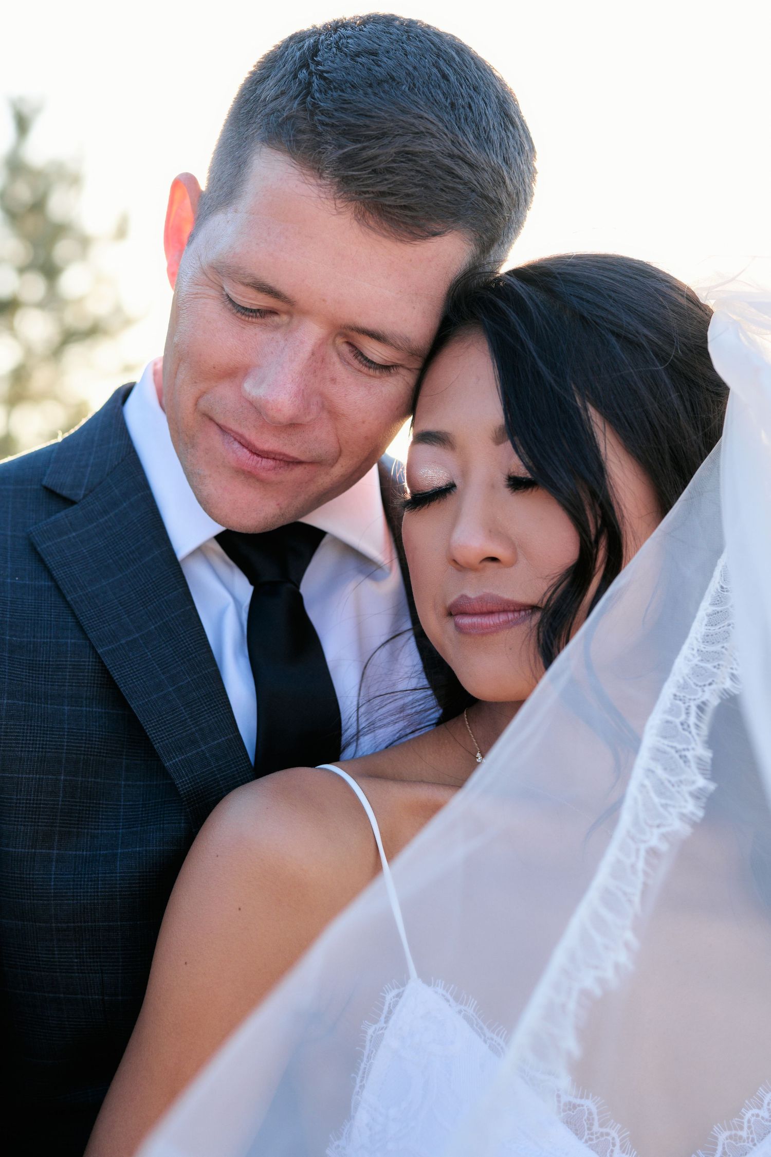 An intimate wedding portrait captured during golden hour outdoors.