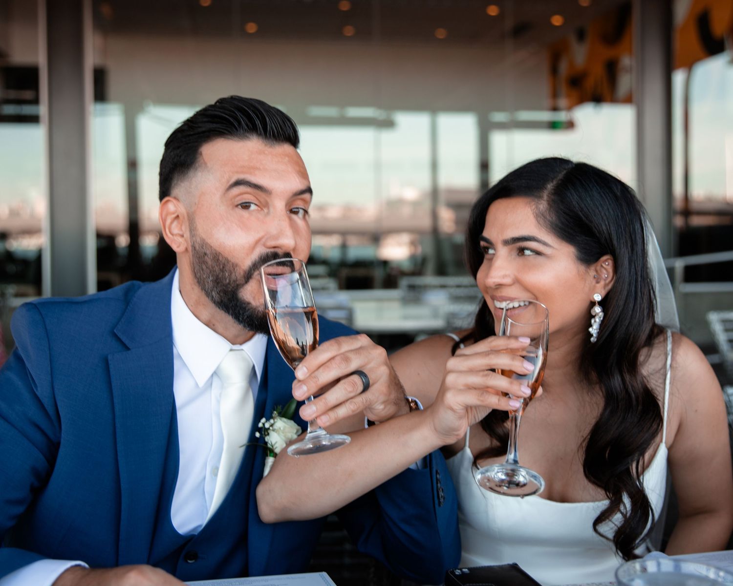 Candid reception moments captured indoors with champagne and laughter.