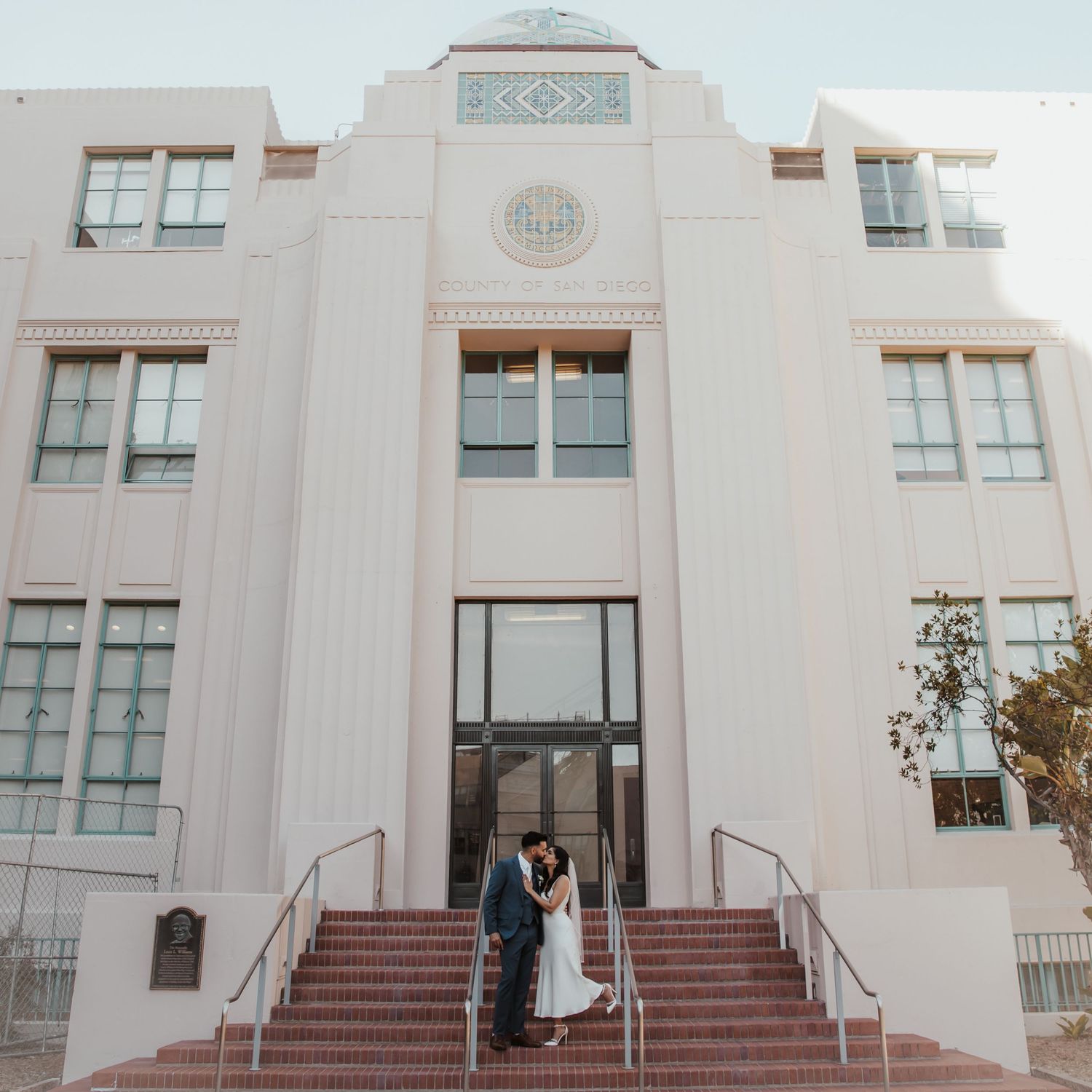 Panoramic view of an elegant white art deco building with symmetrical steps and windows.