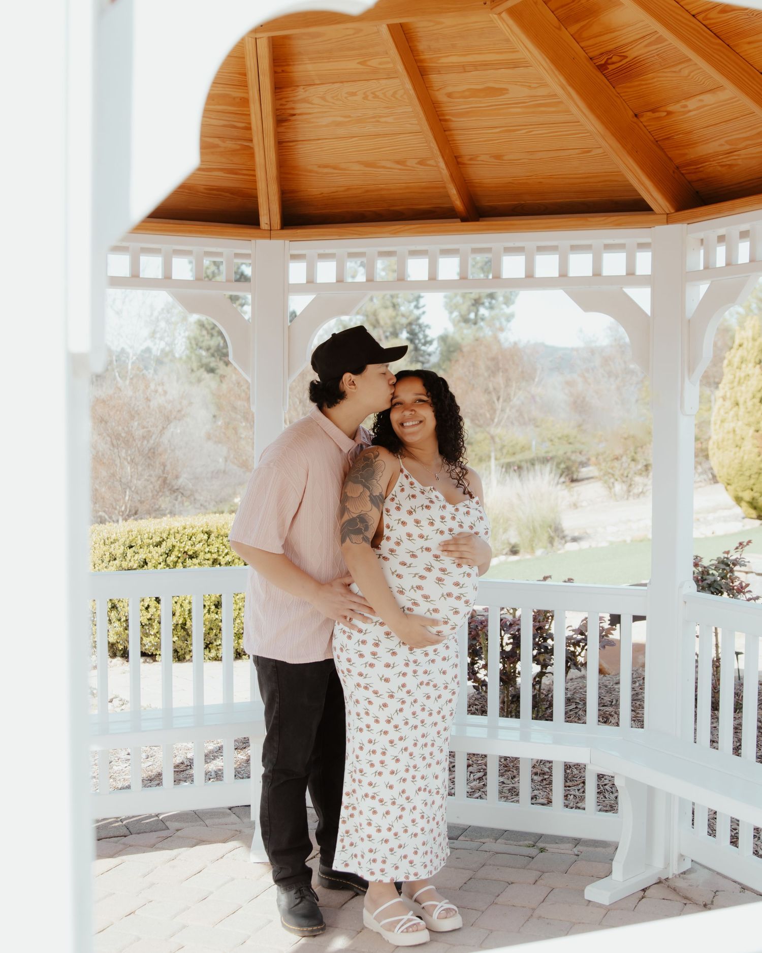 A romantic moment captured under a wooden gazebo with white railings.