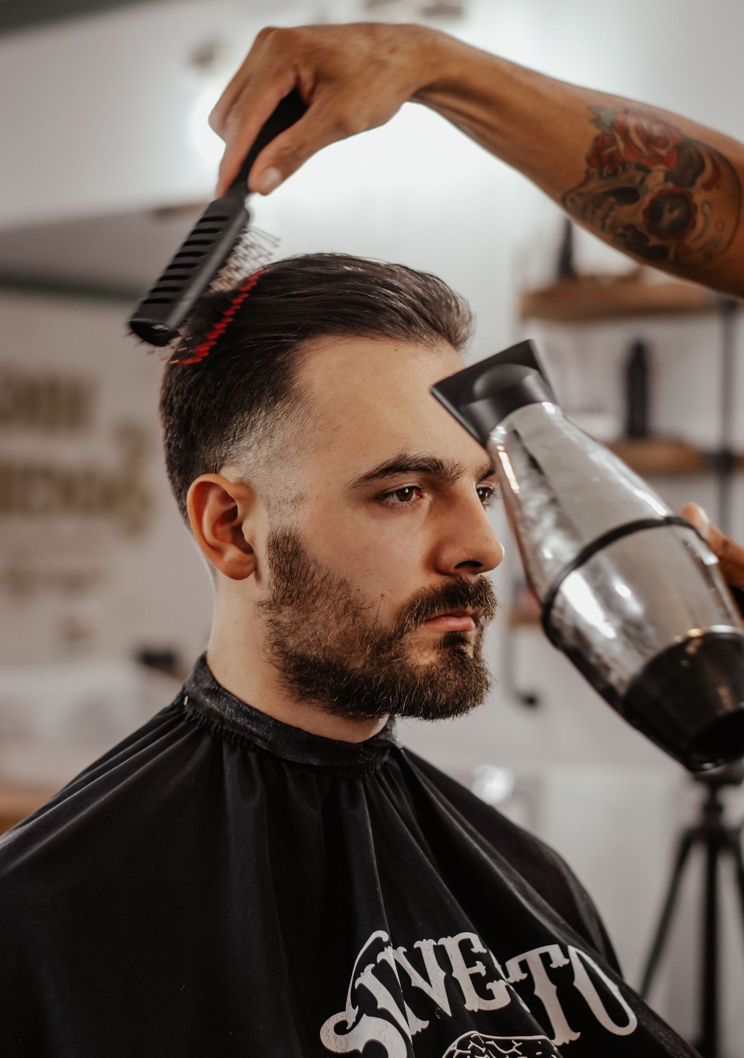 Professional barber giving stylish haircut in modern barbershop setting.