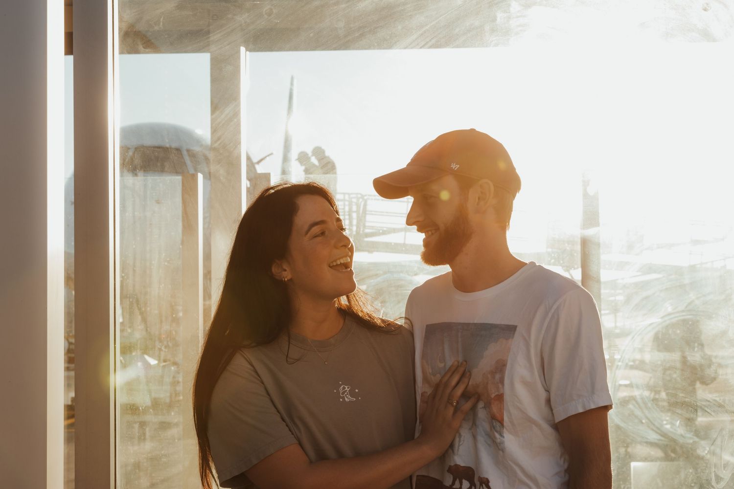 Couple sharing intimate moments during golden hour with sunlit background.