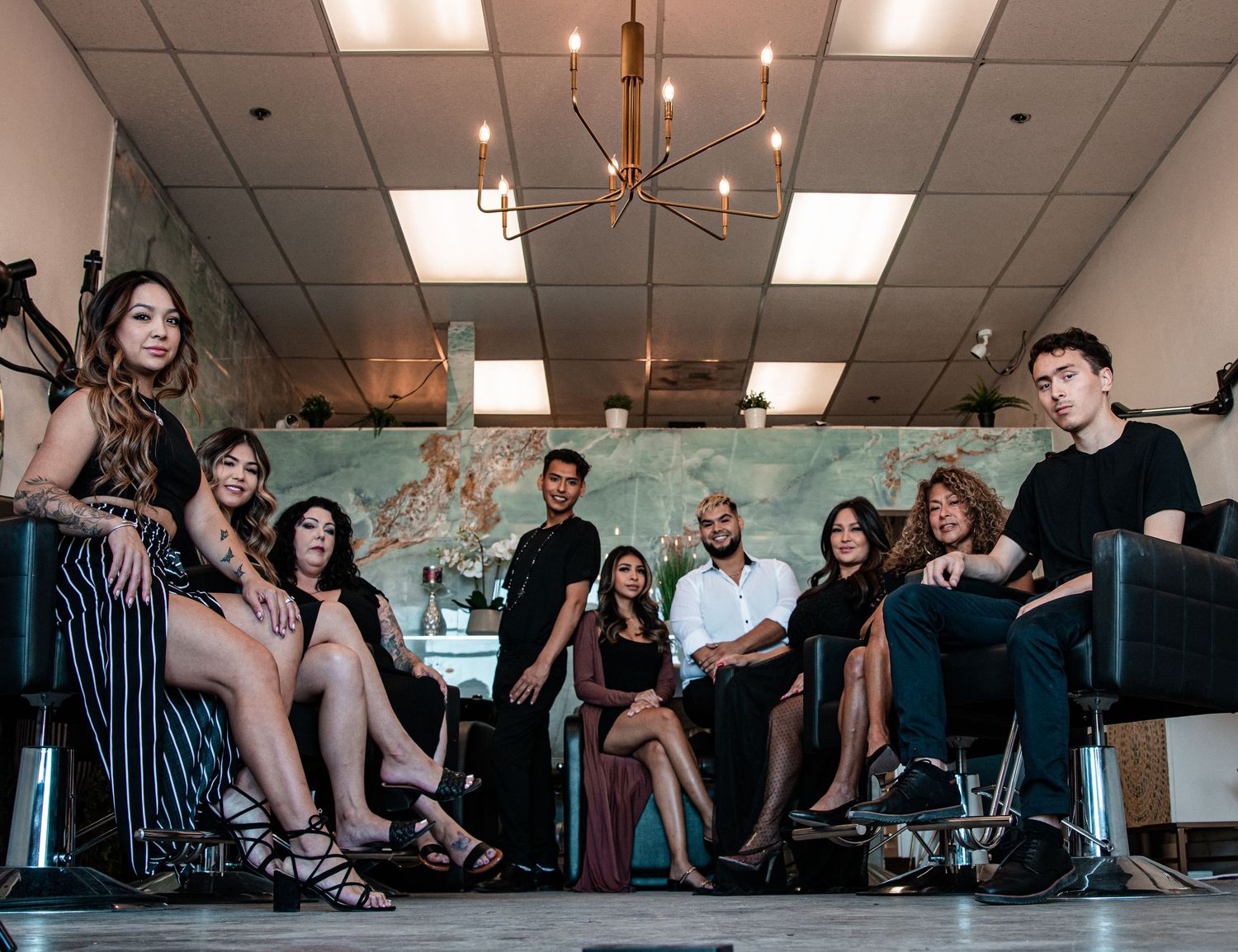 Group photo in modern salon setting with stylish decor and lighting.