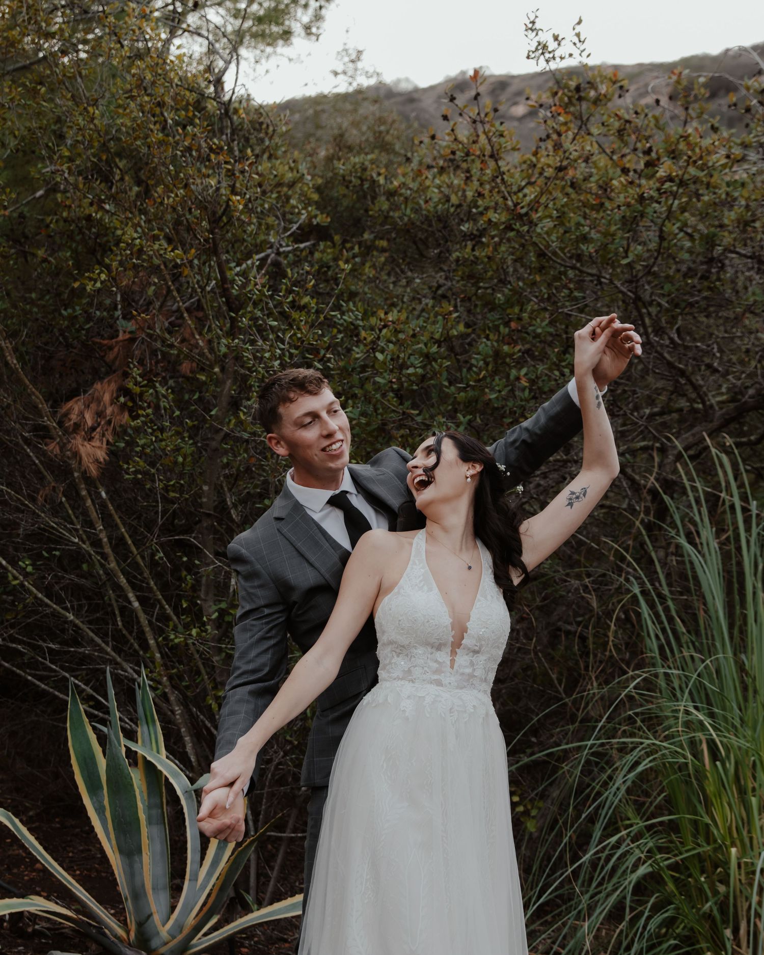 A couple sharing a joyful moment together in a garden setting with agave plants.