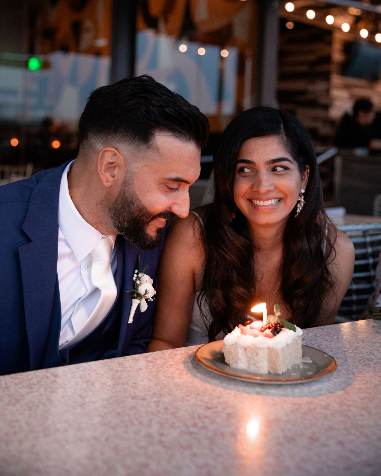 Romantic couple shares intimate moments at a candlelit table in a restaurant.
