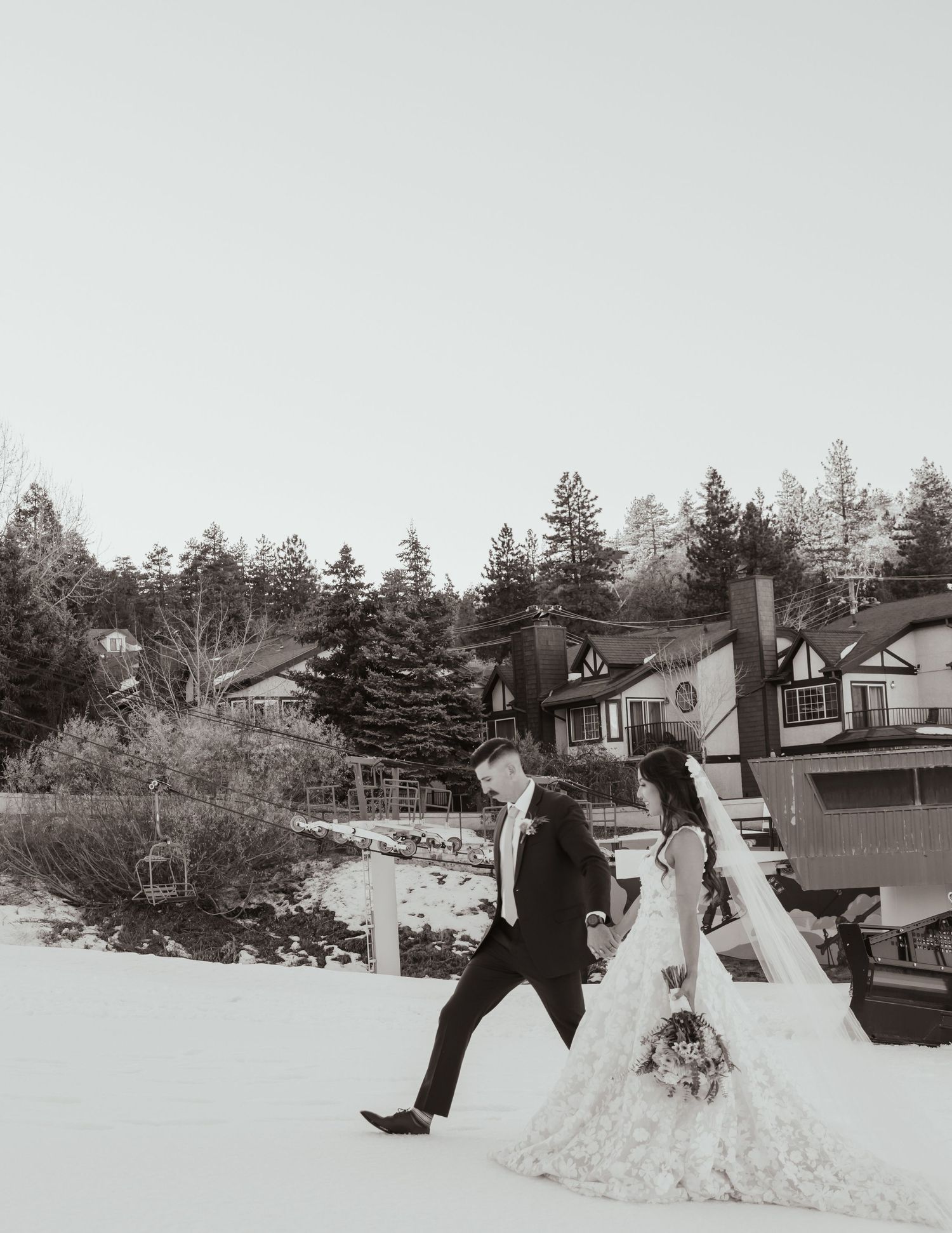 Black and white wedding photography in snowy winter landscape.
