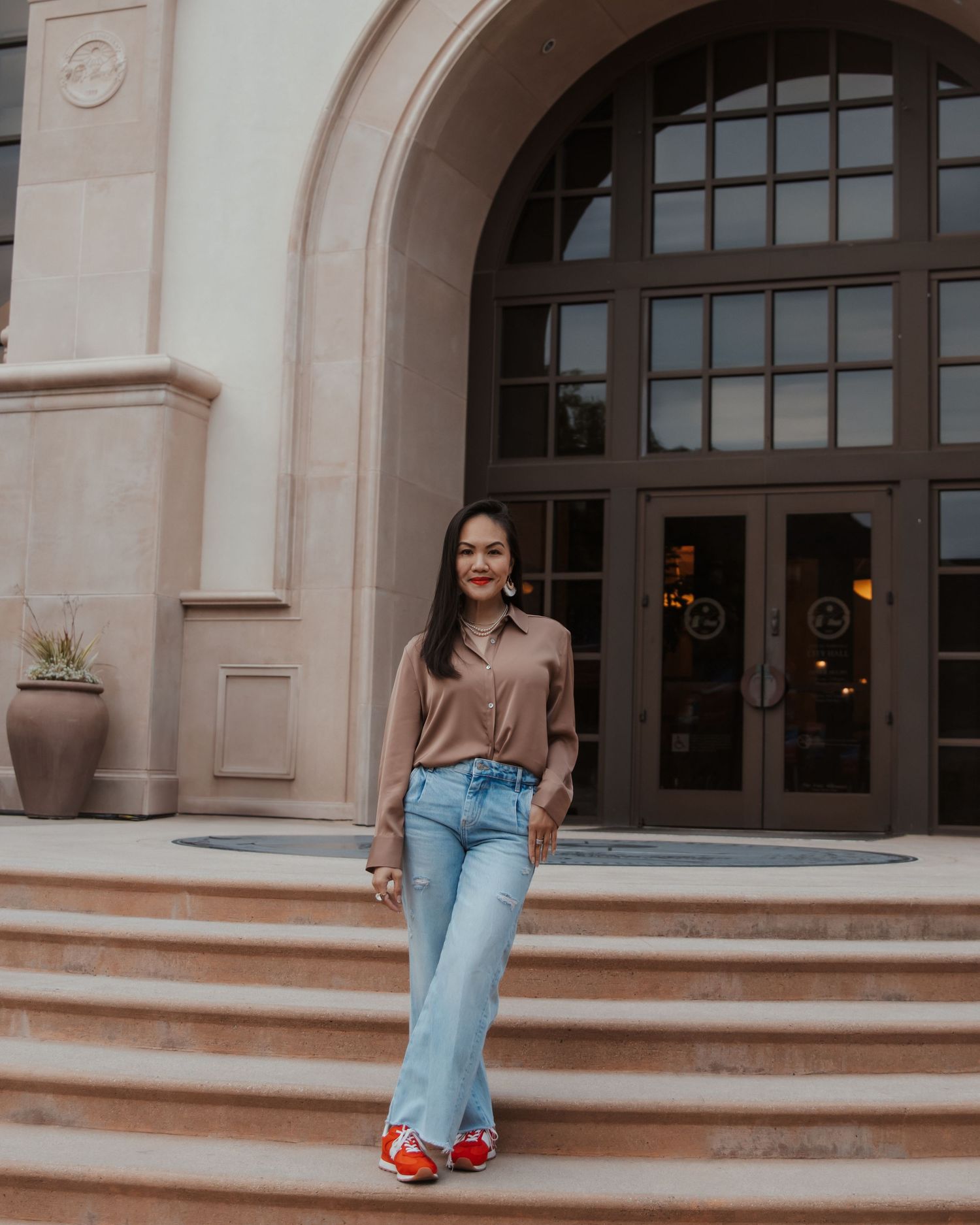 A casual portrait session on stone steps outside a building with arched windows.
