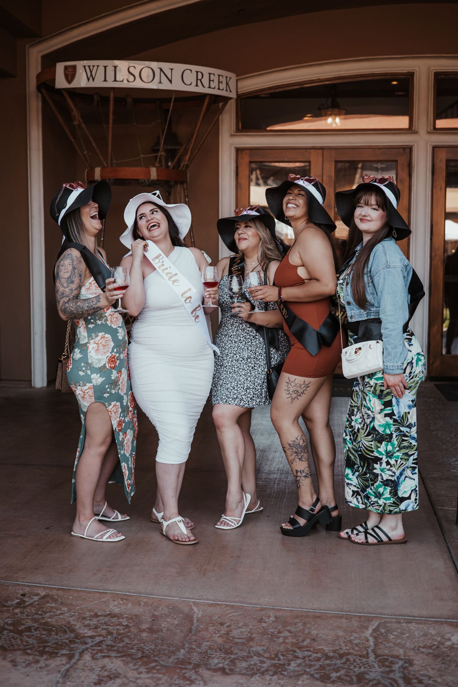 Group of friends in summer dresses posing together at Wilson Creek venue.