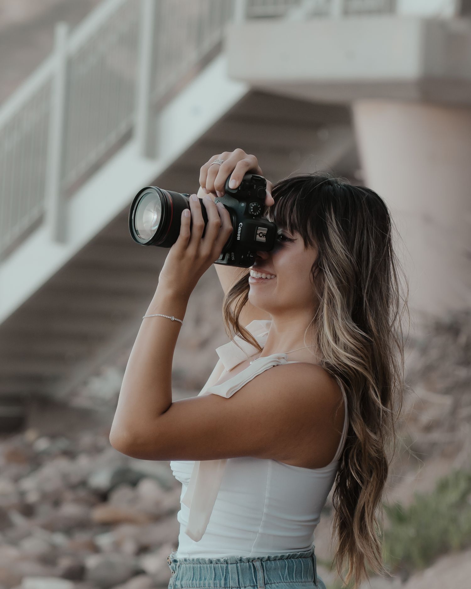Side profile of photographer using professional camera with telephoto lens.