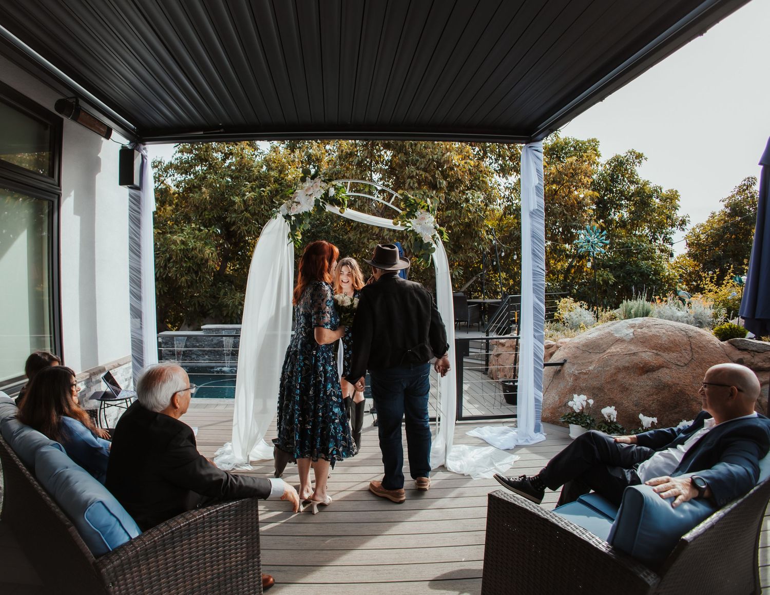 People gathered on an outdoor covered patio during a social event.