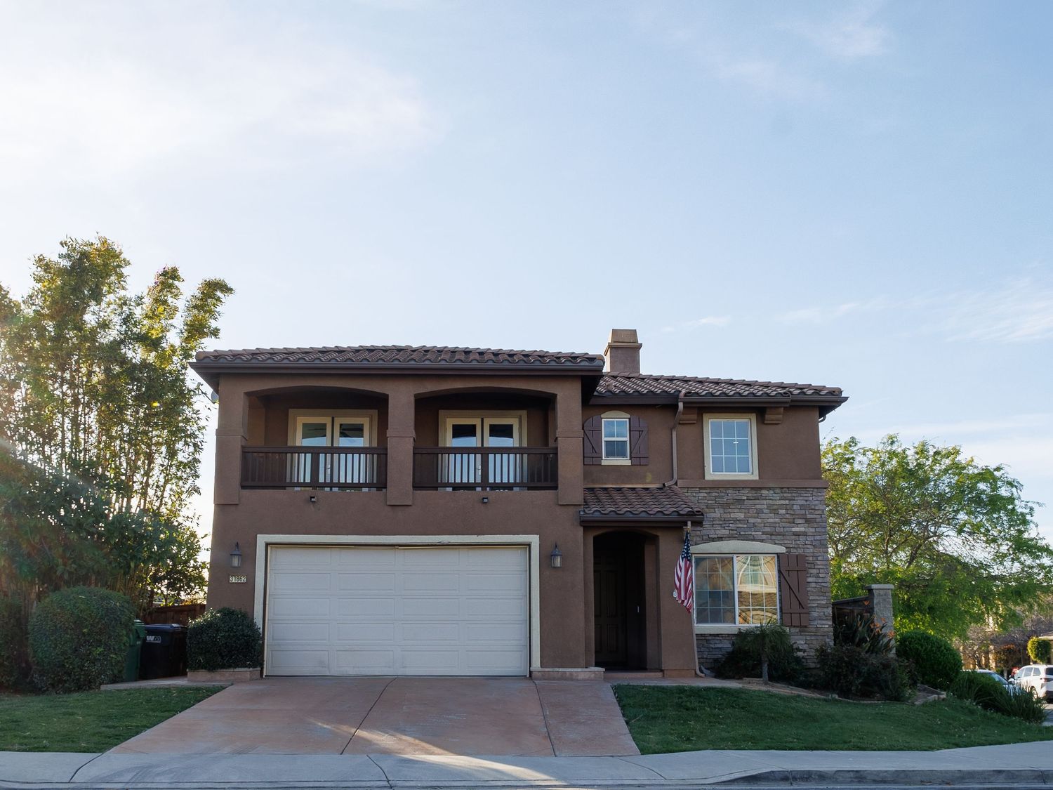 Spanish-style residential home exterior with terra cotta roof tiles and desert landscaping.