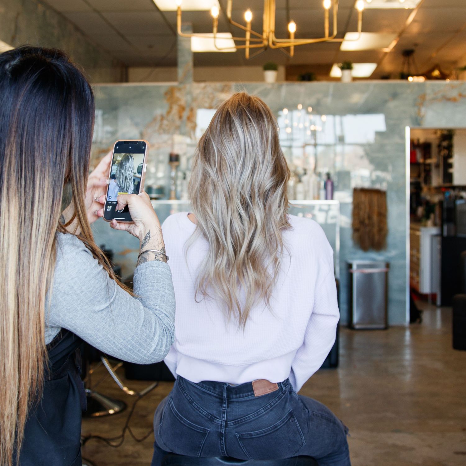Behind-the-scenes photo of someone taking pictures in a modern salon interior.