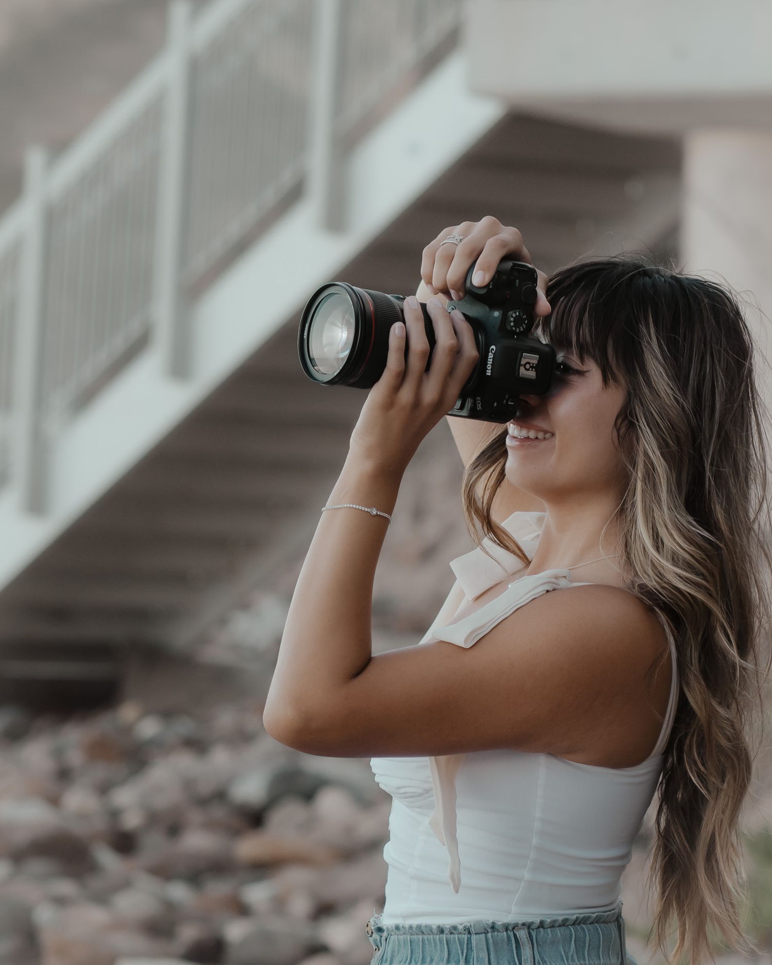 Photographer using professional camera with telephoto lens to take photos outdoors in natural lighting.