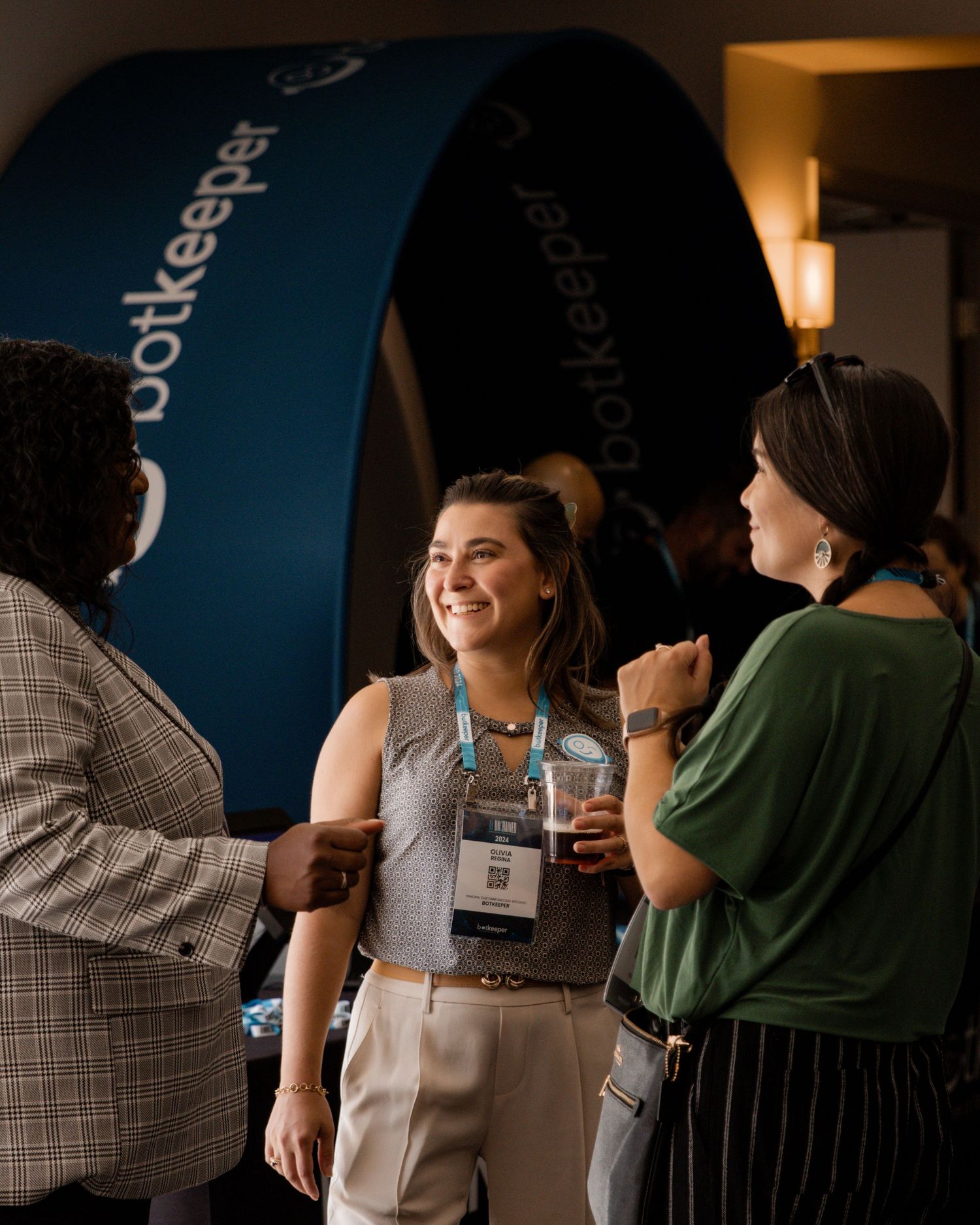 Conference or networking event with attendees interacting in dimly lit venue.
