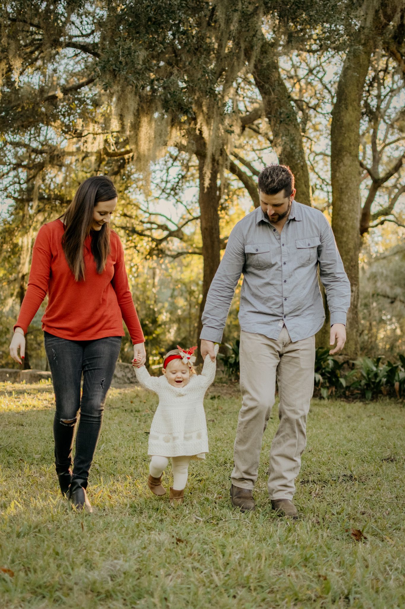 Family walking together outdoors with their dog under trees in a natural lifestyle family photography session