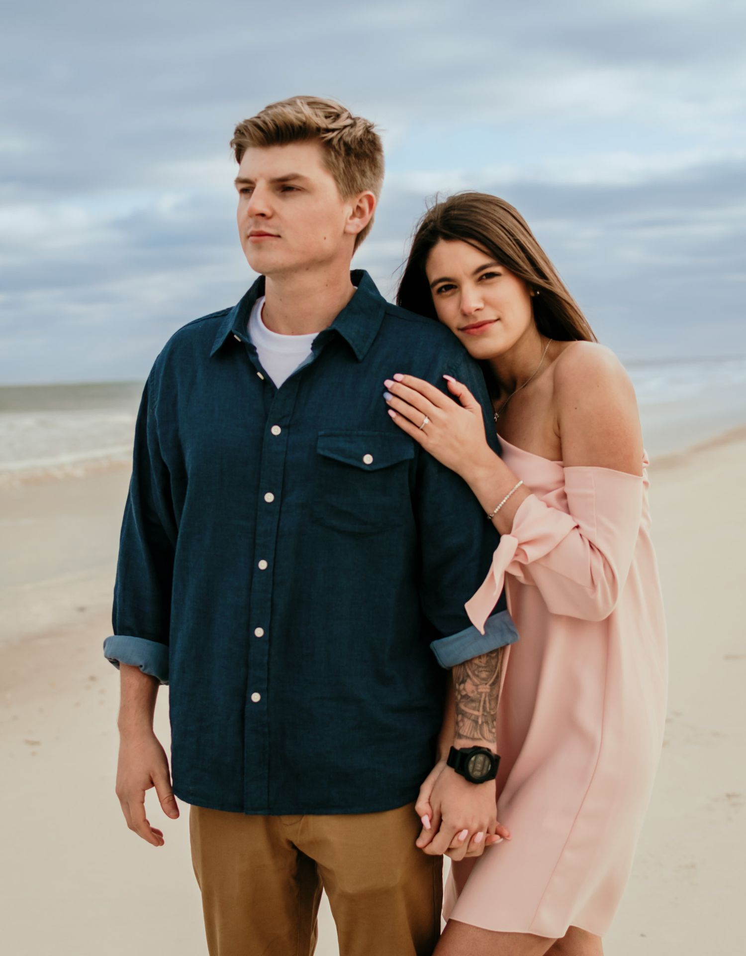 Couple embracing together on the beach during a sunset engagement session