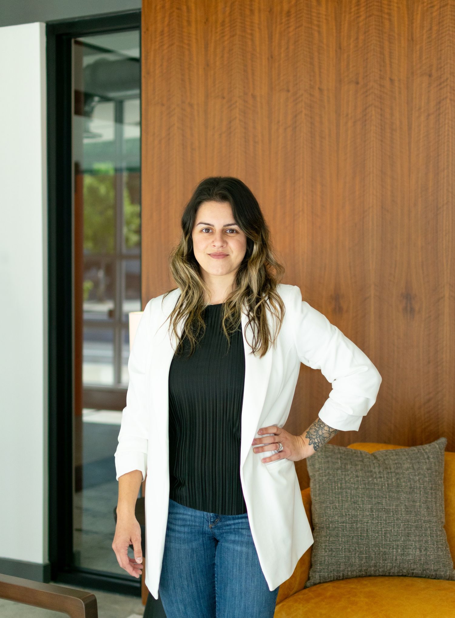 Professional lifestyle portrait of a woman standing indoors near a doorway with natural light