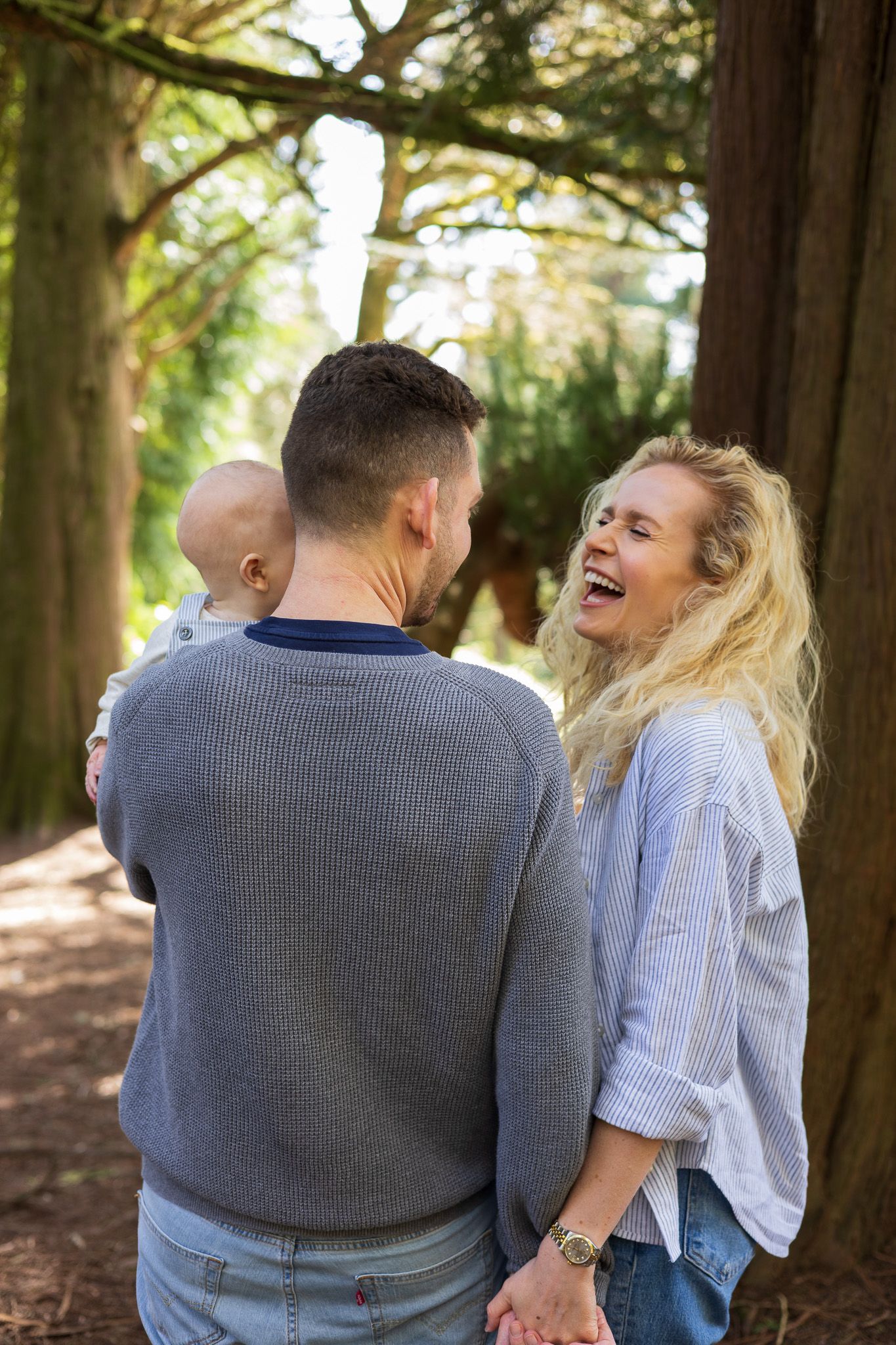 Mother laughing while walking through the woods with her family