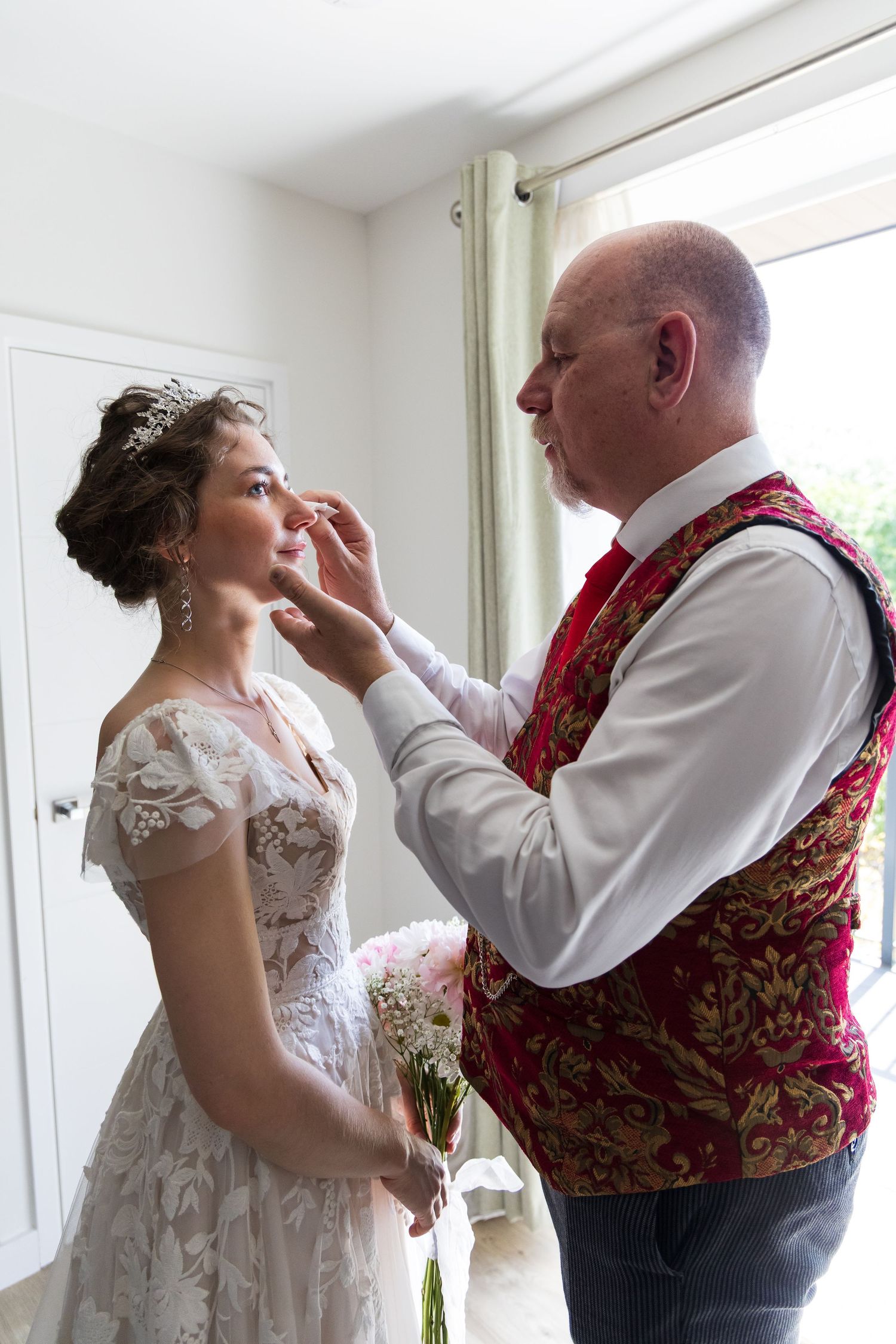 Bride having her earring adjusted by a family member before the ceremony